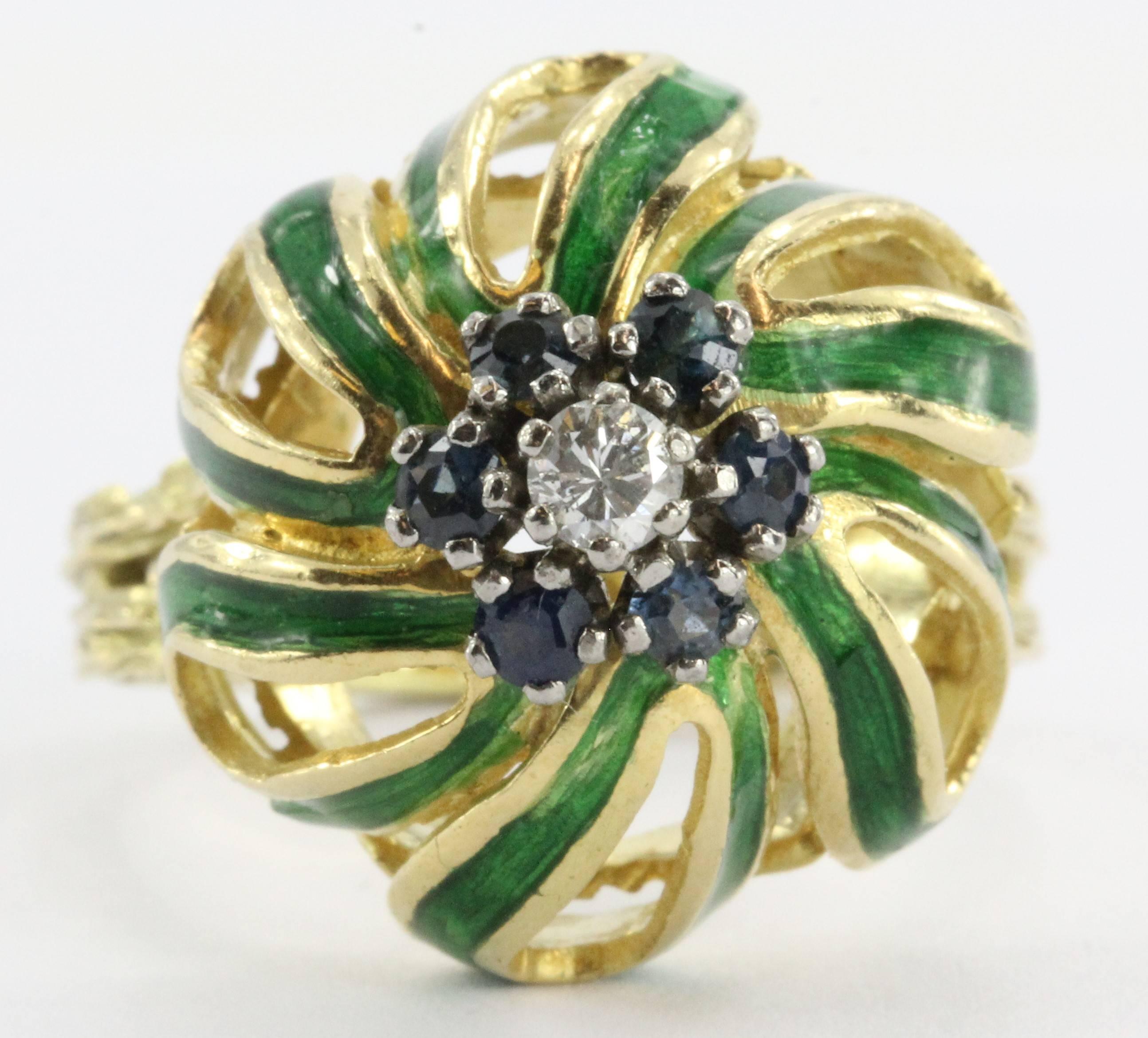 A stunning antique solid 18K yellow gold ring set with swirling green enamel petals and genuine blue sapphires  with a .10 carat white diamond in the center. There is .15 carats of sapphires for a total of .25 carats in gemstones.

The ring is not