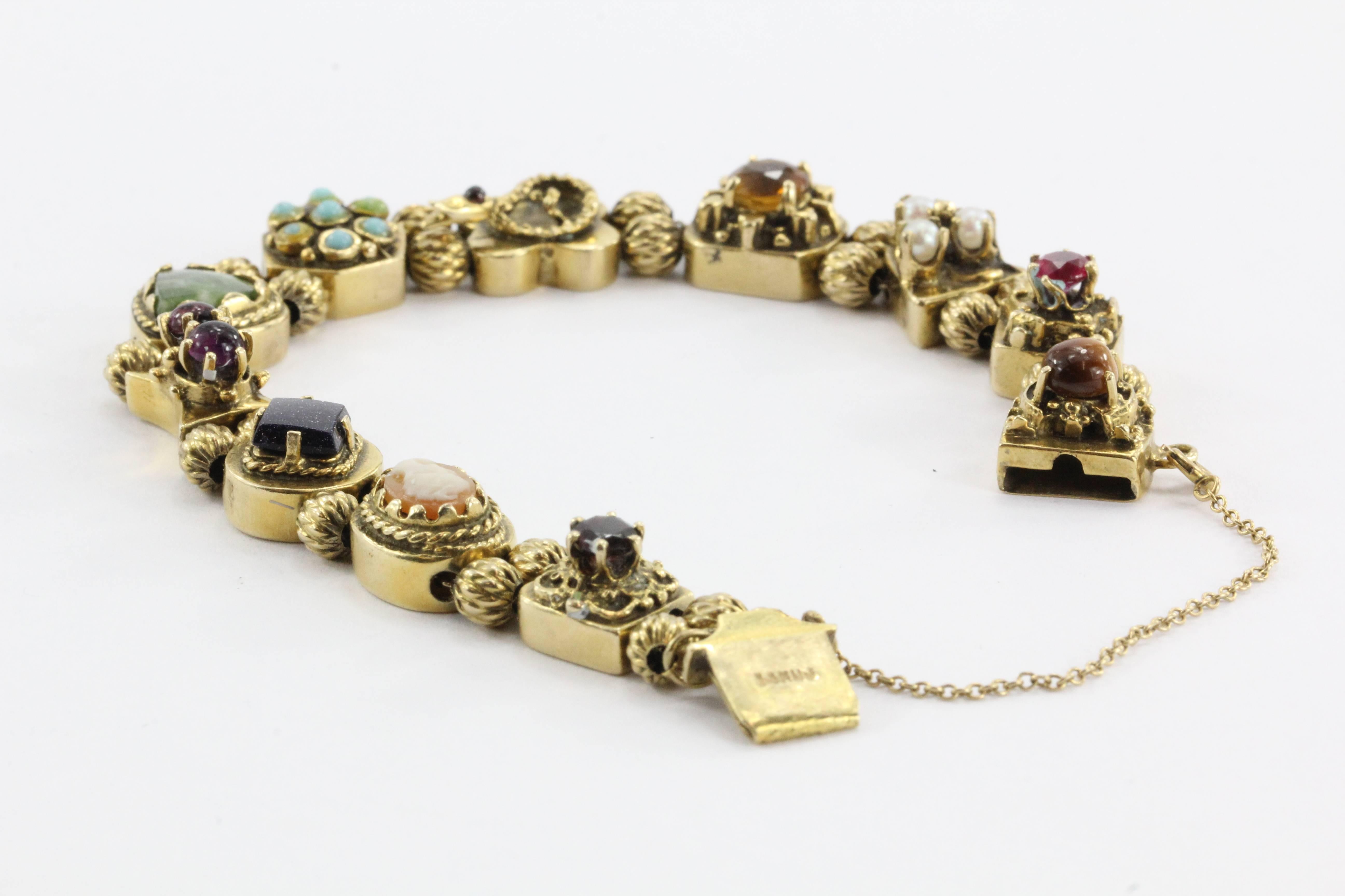 The piece comes loaded with antique gold slides. Both sides of the bracelet are all signed and hallmarked 14K UJ. The clasp has a round tiger's eye bead on it. The rest of the bracelet consists of a ruby slide, a seed pearl slide, a citrine slide, a