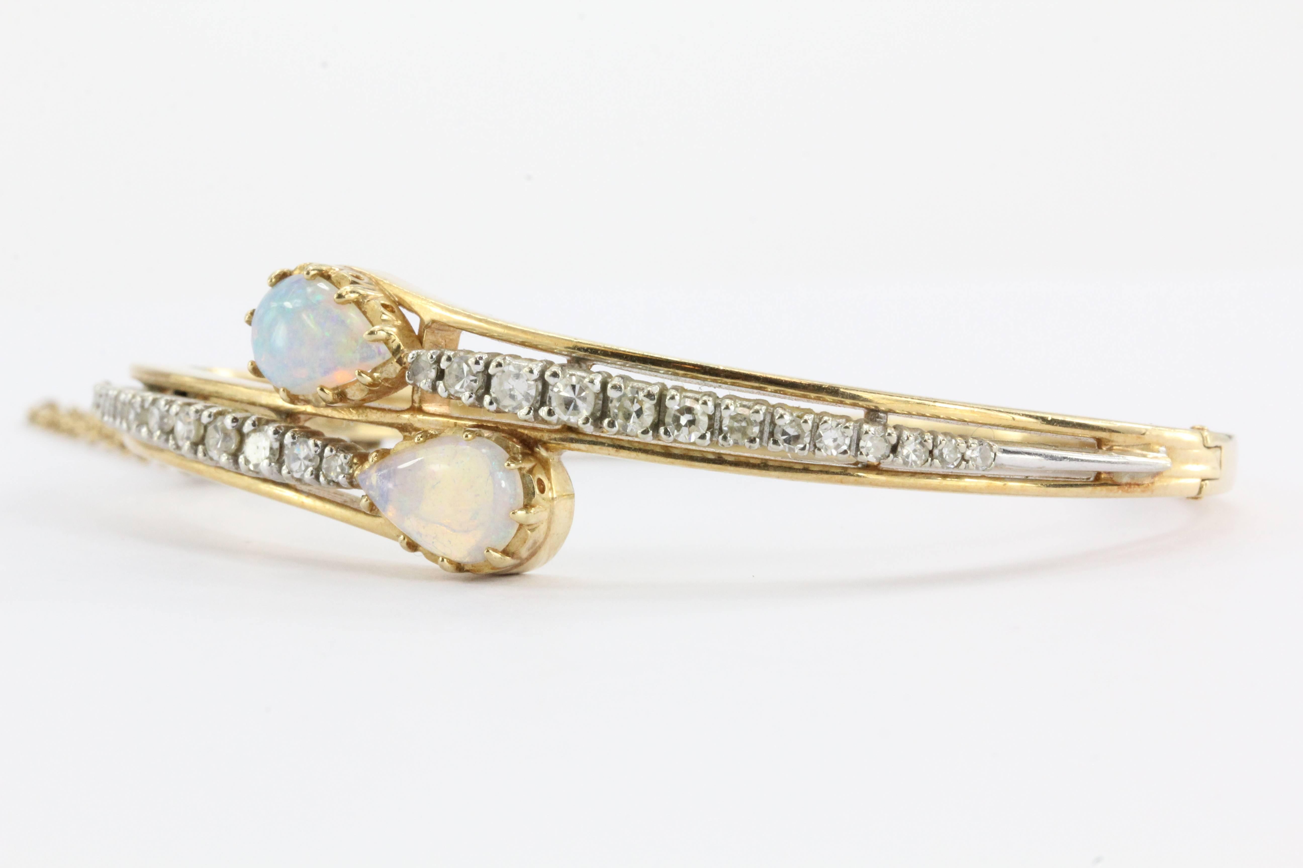 Casbah 14K Gold Diamond & Translucent Opal Bangle Bracelet. The bracelet is in excellent estate condition and ready to wear. It is signed 14K Casbah. The piece is mostly 14K yellow gold with two thin applied parts of 14K white gold. It is set with