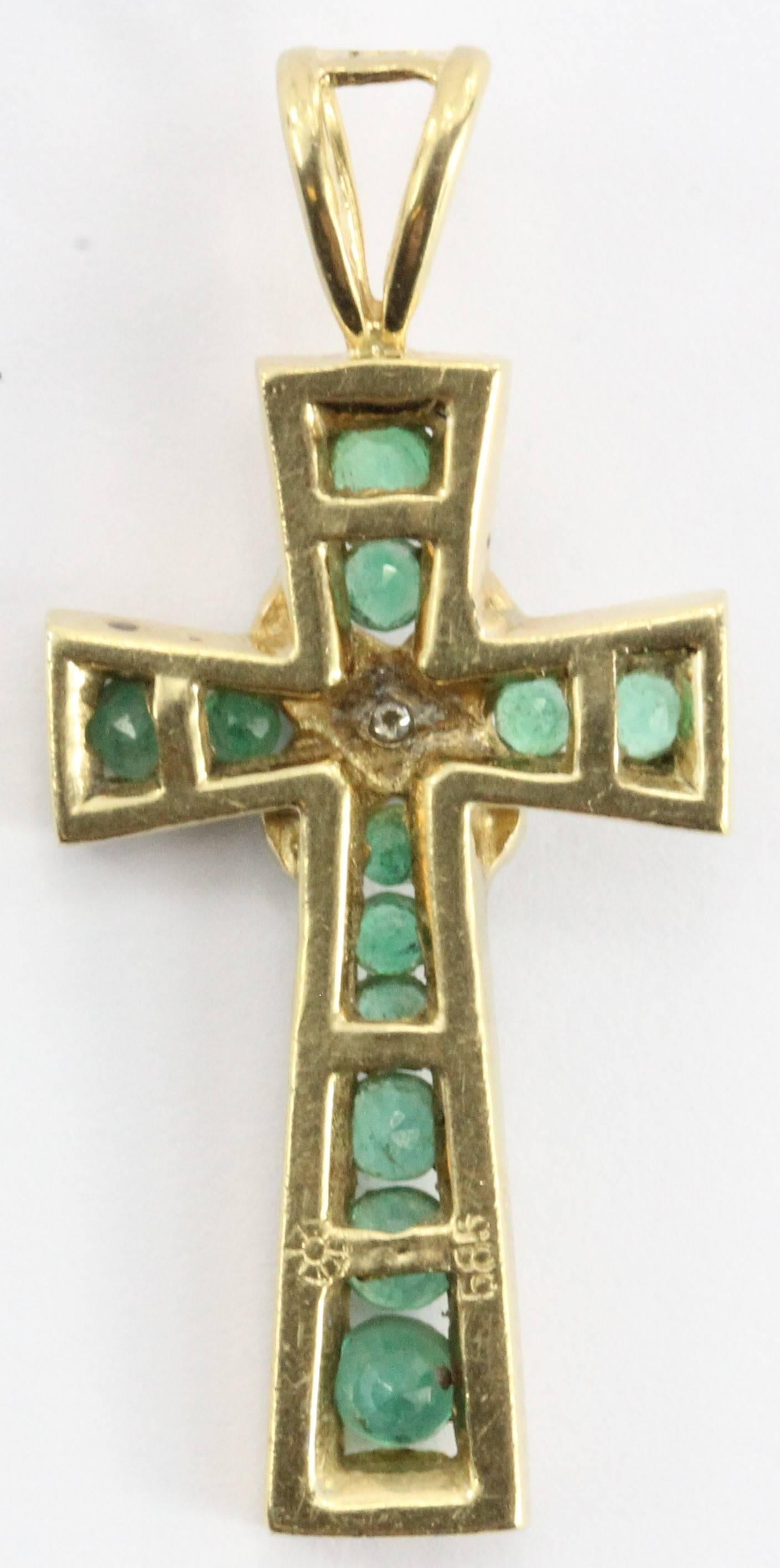Vintage 14K yellow gold cross pendant set with about 1 carat of Columbian Emeralds and one small diamond chip in the center. The piece is in excellent estate condition and ready to wear. It is hallmarked 585 for 14K and the company hallmark that I