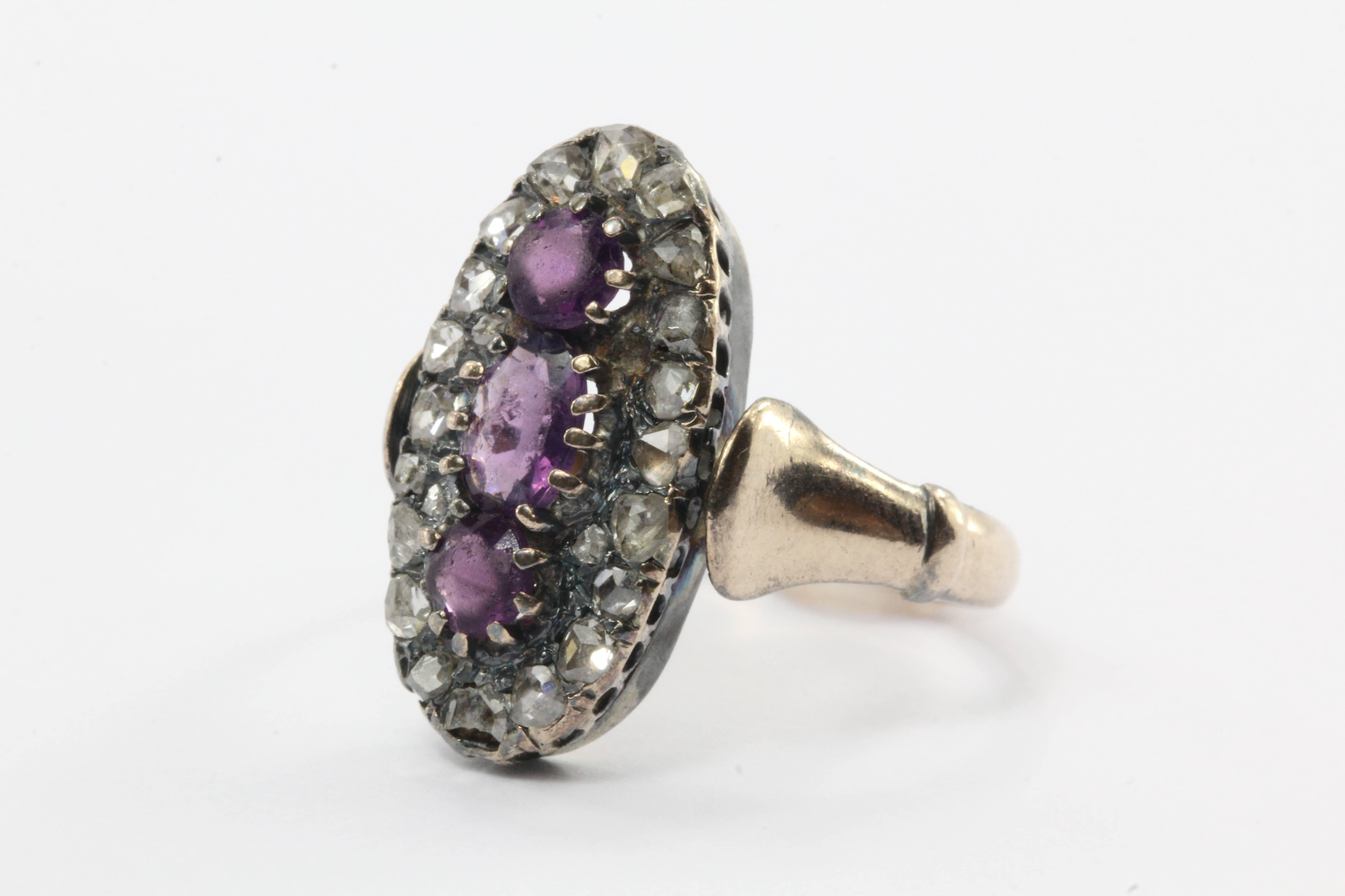 Antique 10K Gold Georgian Rose Cut Diamond Purple Paste Ring. The ring is made of 10K yellow gold but the stones are set in sterling silver. The piece is set with 20 genuine rose cut diamonds. One of the diamonds is cracked. The three purple stones
