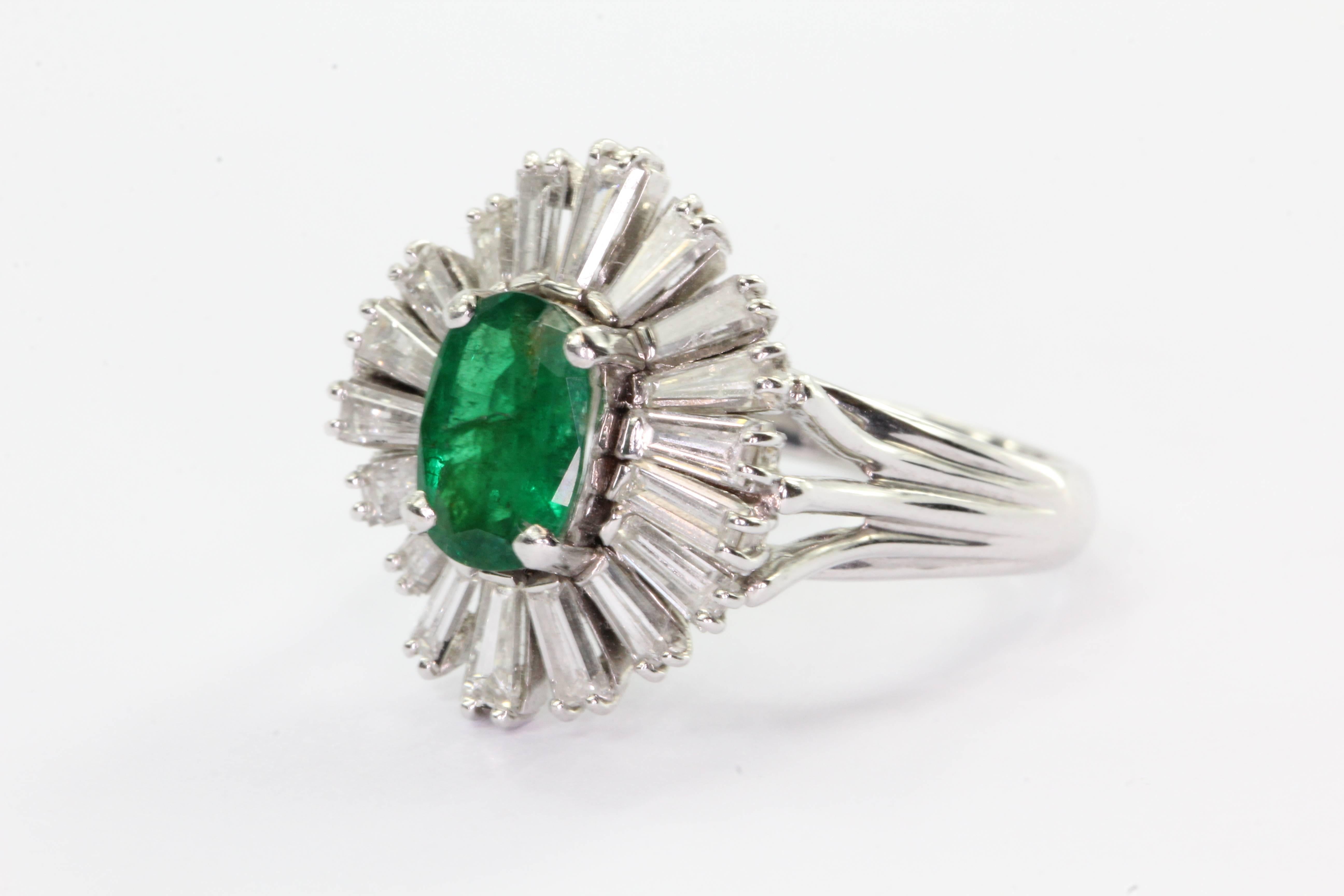 Vintage 14K White Gold Emerald & Diamond 1.2 CTW Retro Starburst Ring. The ring is in excellent estate condition and ready to wear. It is hallmarked 14K. The .80 carat oval cut emerald is completely natural. It is surrounded by a halo of