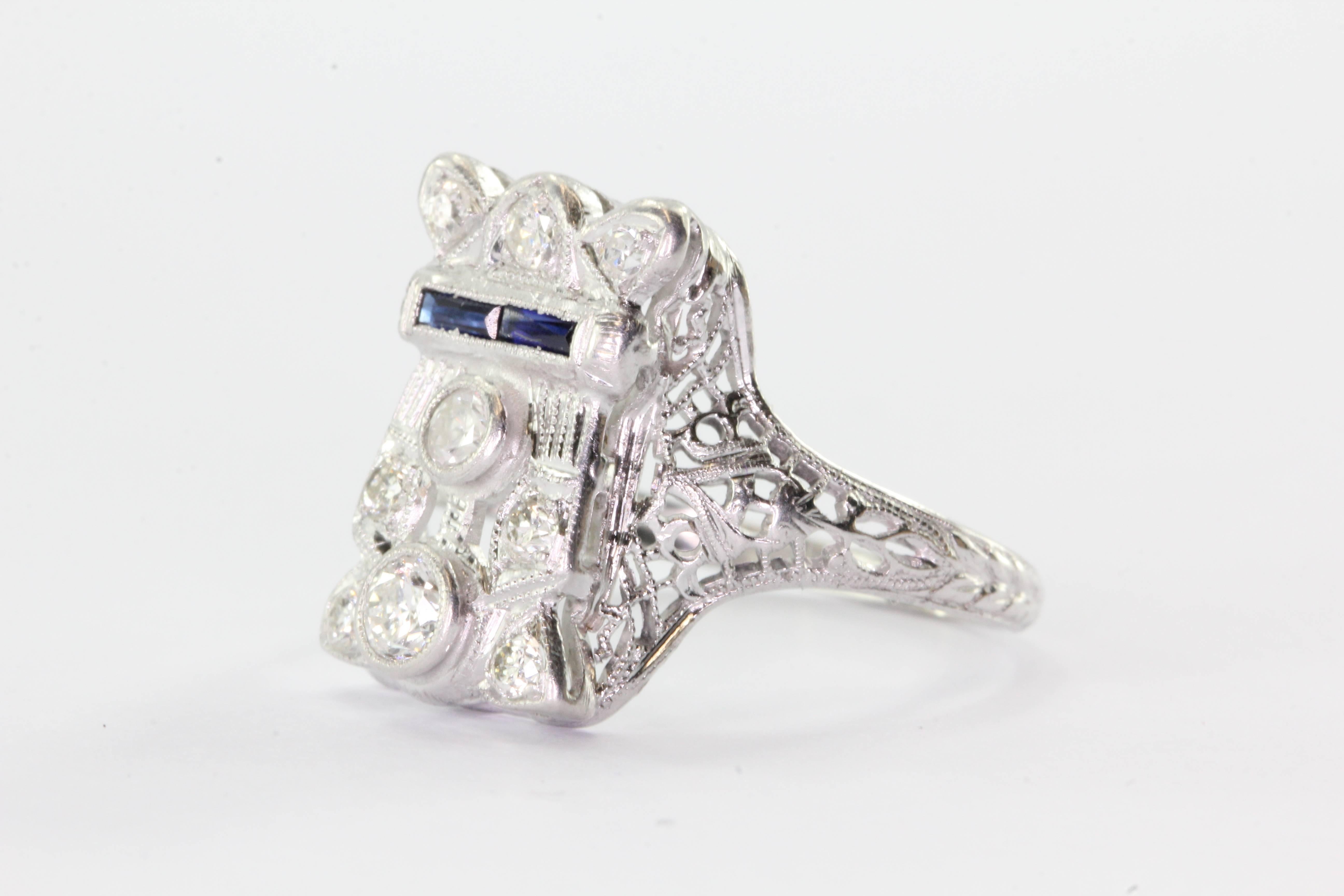 Antique Art Deco 14K White Gold Belais Diamond & Sapphire Ring. The ring is in excellent estate condition and ready to wear. It is signed BELAIS 14K. It is set with some single cut, old European cut and transition cut diamonds as well as a band of