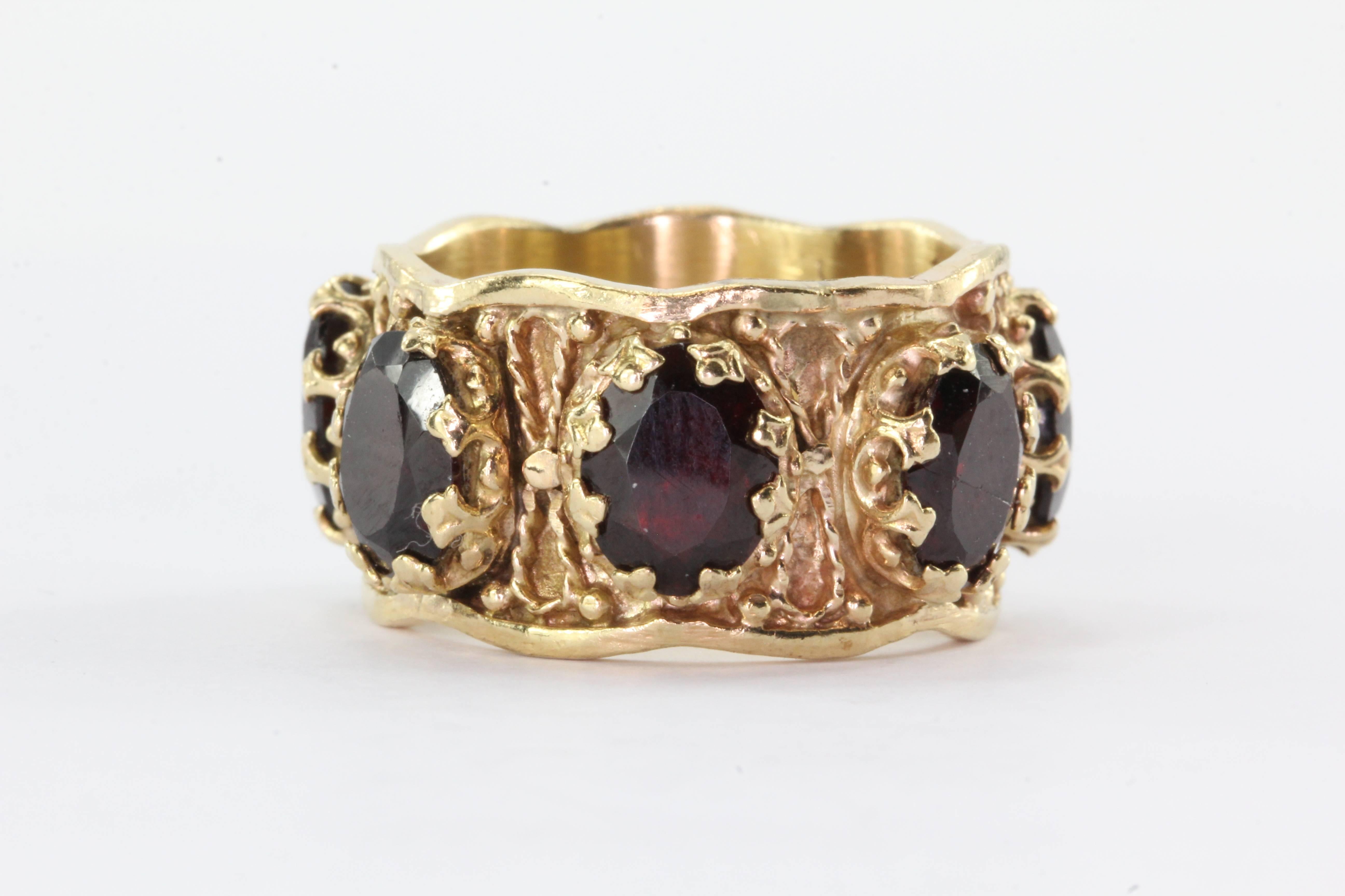 Gothic Revival Chunky 14K Gold Garnet Eternity Band Ring. The ring is in great estate condition, ready to wear, one of the garnets is cracked. It is set with seven oval cut garnets that come to 5.5 carats total. They wrap completely around the ring.