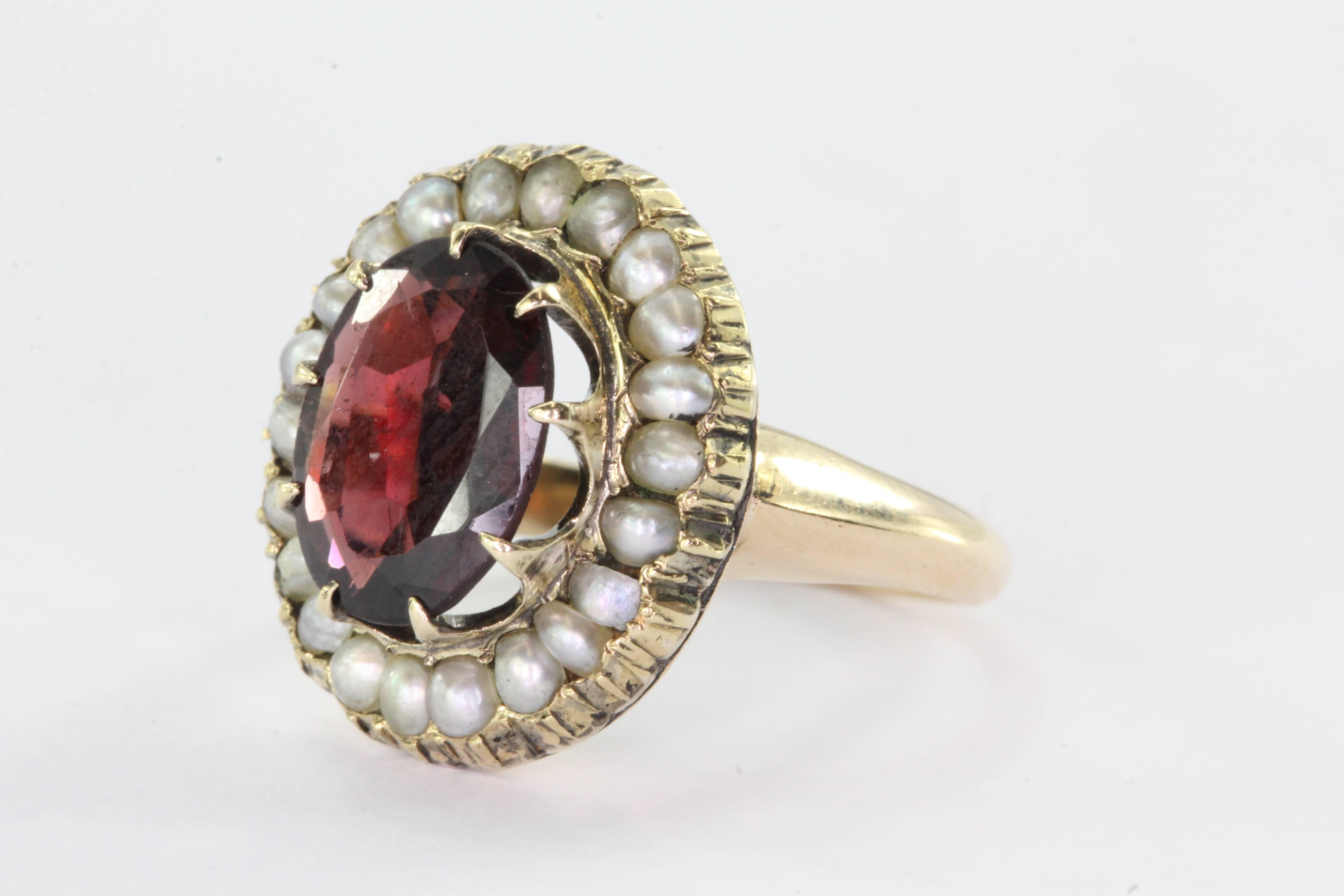 Victorian 14K Gold Garnet Seed Pearl Halo Ring. The ring is in excellent estate condition and ready to wear. The garnet measures 9.9mm x 7.1mm x 2.6mm. The ring is a size 3 and weighs a total of 4.5 grams.