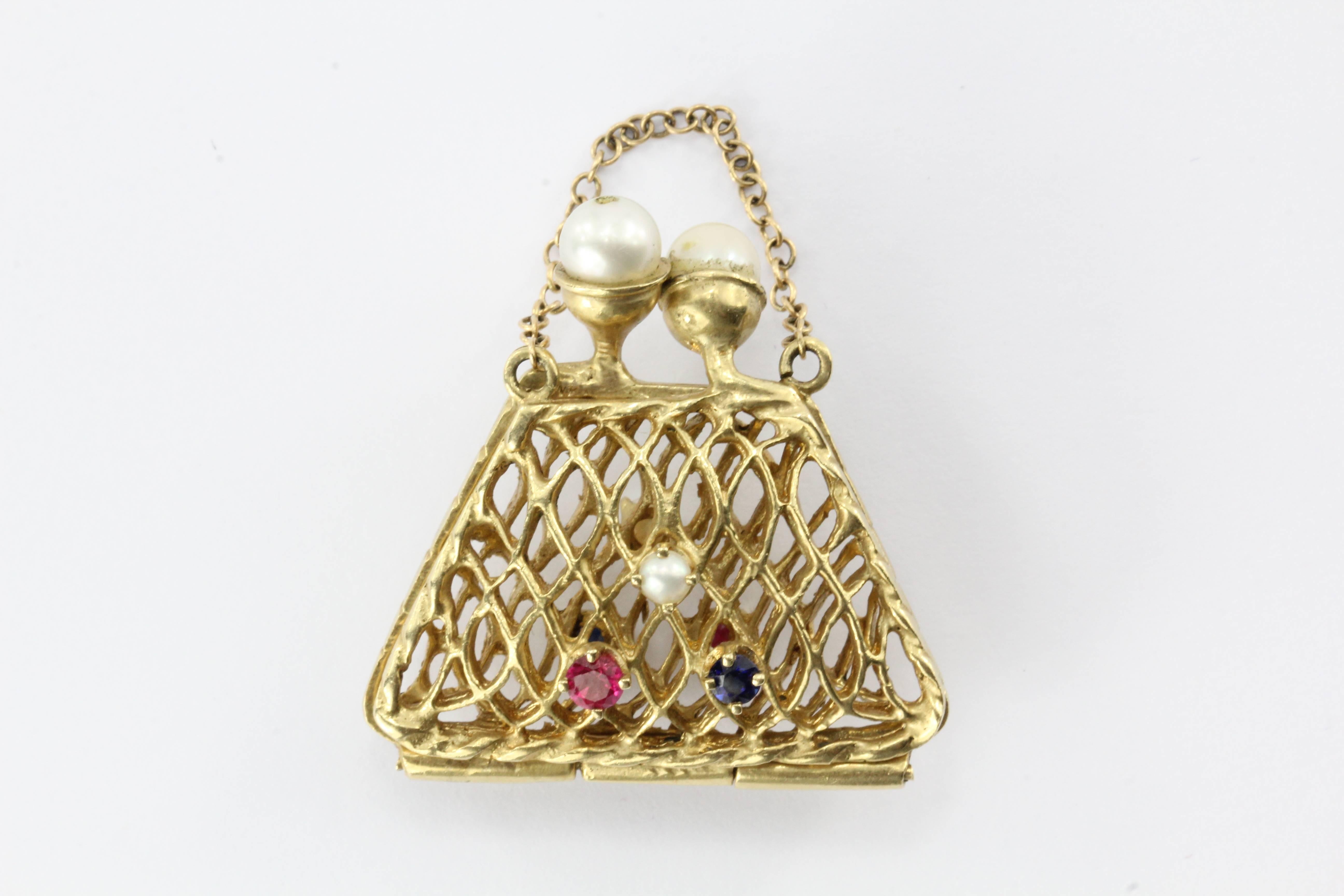 14K Gold Woven Sapphire, Ruby, & Pearl Opening Purse Pendant / Charm. The piece is in great estate condition and ready to wear. One of the pearls on the clasp is a replacement. The piece is signed 14K. The piece measures 1.25