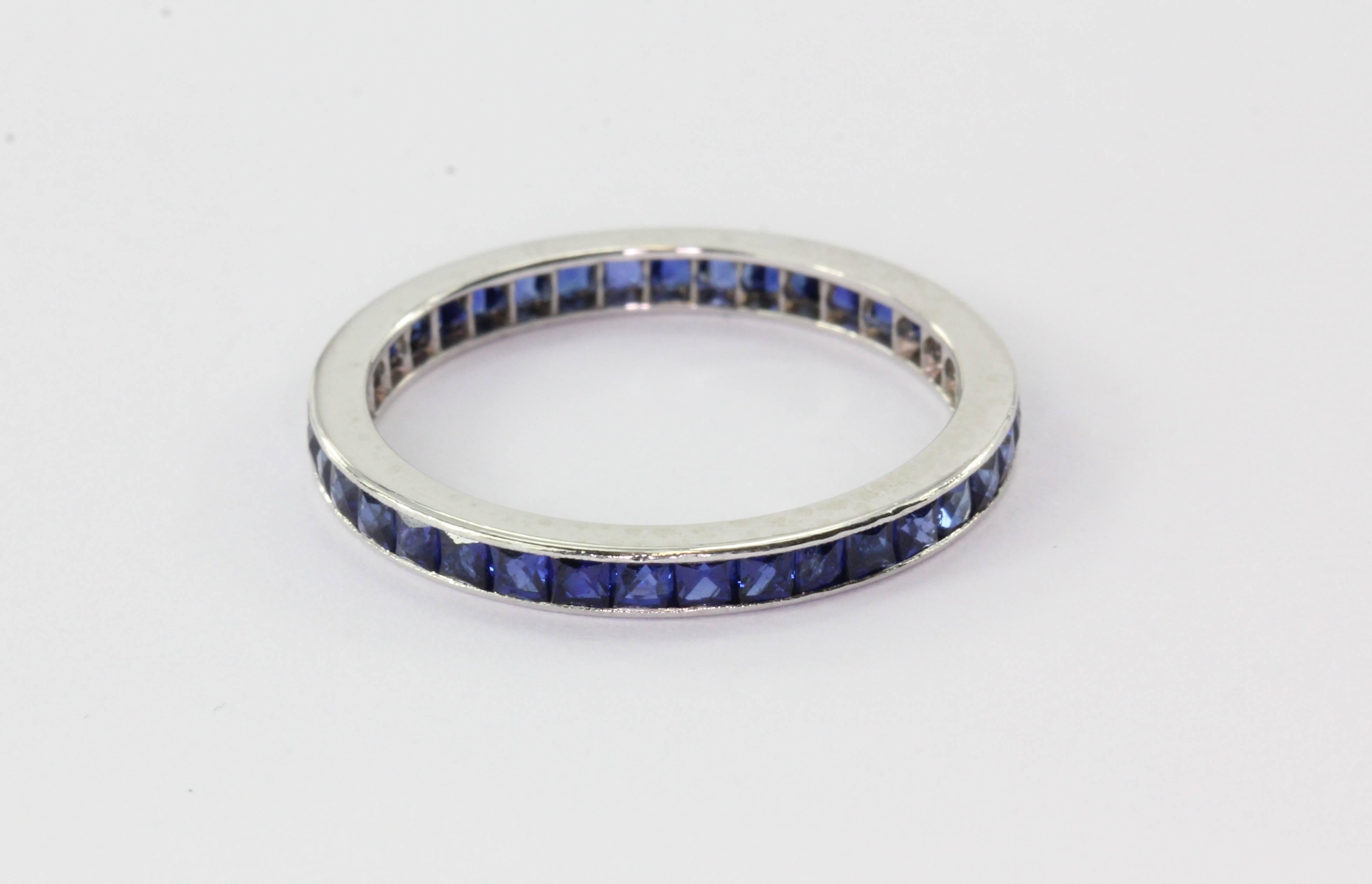 Platinum Art Deco French Cut Sapphire Eternity Band Size 5.75. The ring is in excellent estate condition and ready to wear. The piece is set with 35 French cut blue sapphires that come to approximately 1 carat total. The ring is a size 5.75, it