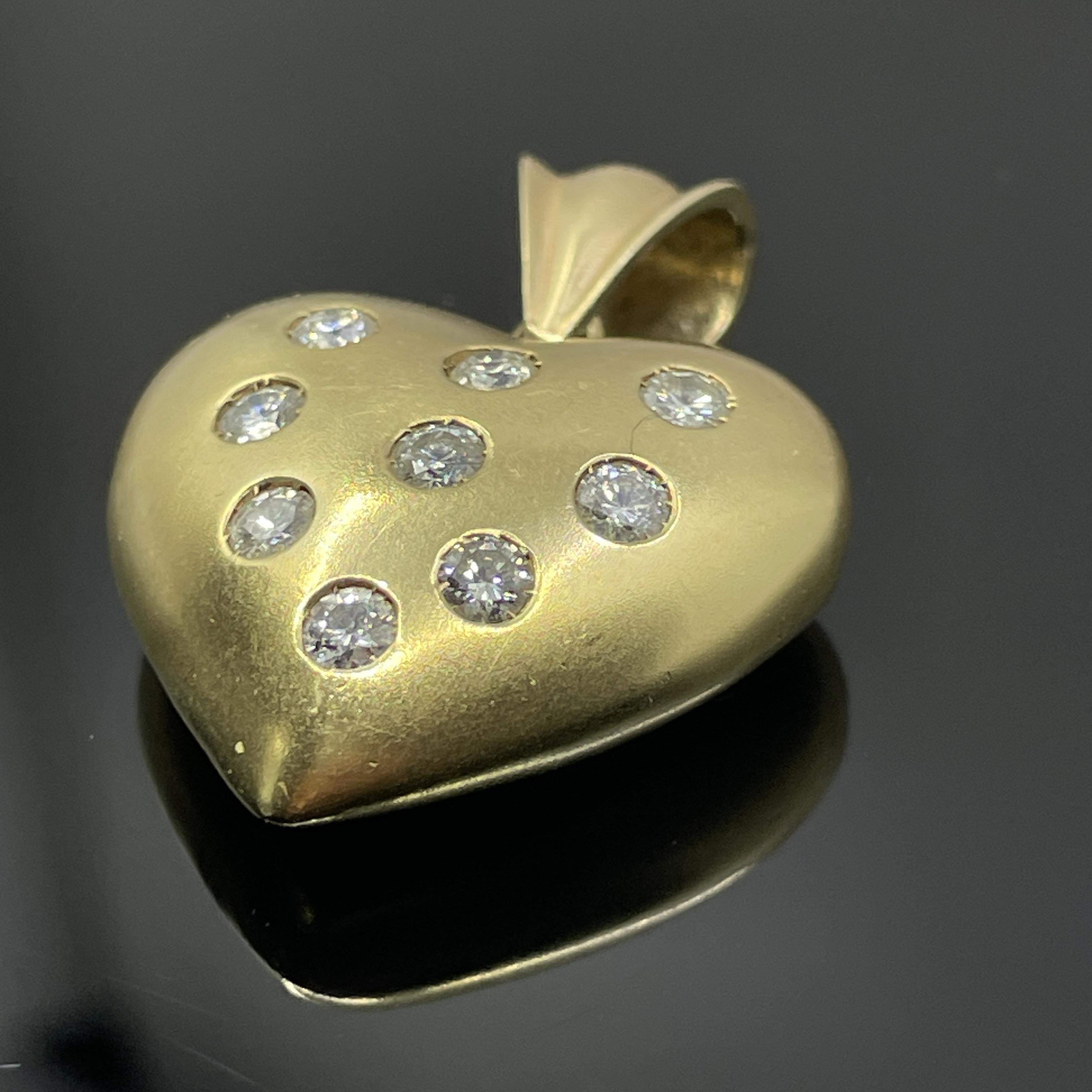 Ciondolo a forma di cuore in oro giallo 18k con diamanti - 0,82 ct.

Questo elegante pendente a forma di cuore è realizzato in oro giallo massiccio 18 carati e incastonato con nove diamanti rotondi taglio brillante per un totale di circa 0,82