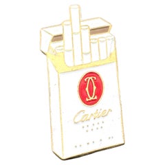 Pin's promotionnel vintage en émail Cartier « Les Must de Cartier » représentant des cigarettes, par L.Y. Paris