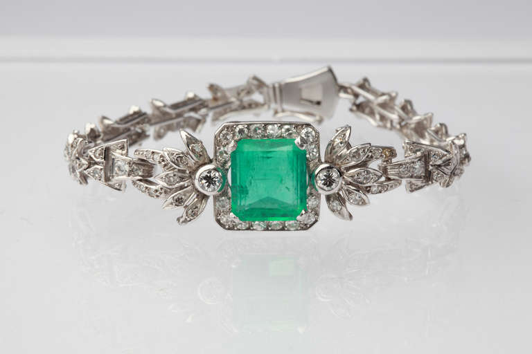 Set at the centre with a rectangular-cut colombian emerald weighing 3,70 carats, edged with filigree elaborated blossom halves.
2 diamonds in brilliant-cut and 113 rectangular diamonds weighing circa 1,71 carats. Mounted in platinum. Hallmarked: