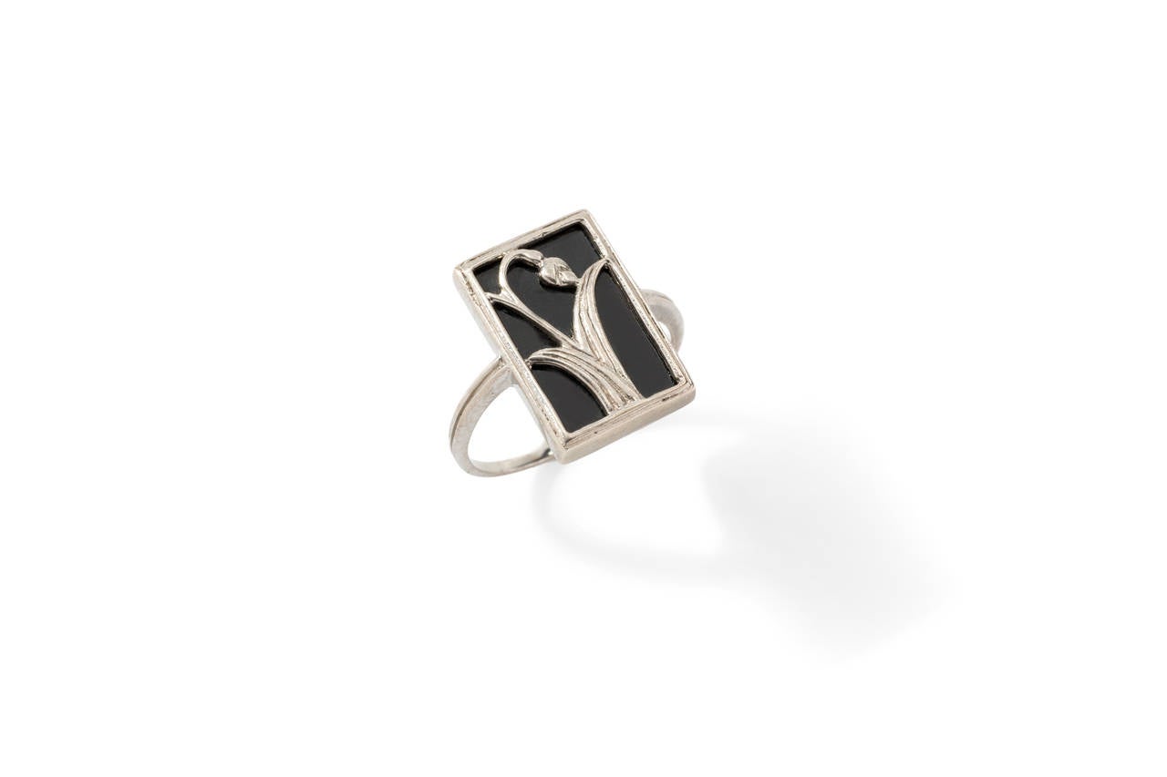 Rectangular stylish  ring, a typical piece from Art Nouveau period. Onyx plate is decorated with silver flower. Re-sizable

height: 0.71 in ( 1,8 cm ), width: 0.47 in ( 1,2 cm ), depth: 0.14 in ( 0,35 cm )

US size 8 or European size 58.