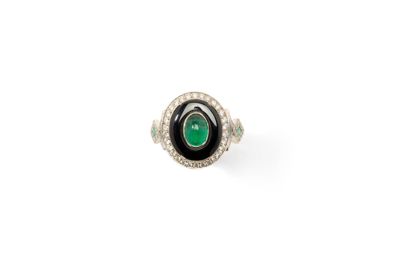 Germany, 1970's. One oval emerald in cabochon-cut approximately 0,92 ct., 2 emeralds in french-cut, onyx and 68 diamonds in brilliant-cut about 0,40 ct. Mounted in 18K white gold. Hallmarked inside with the purity mark: 18 K. Total weight: 5,61 g