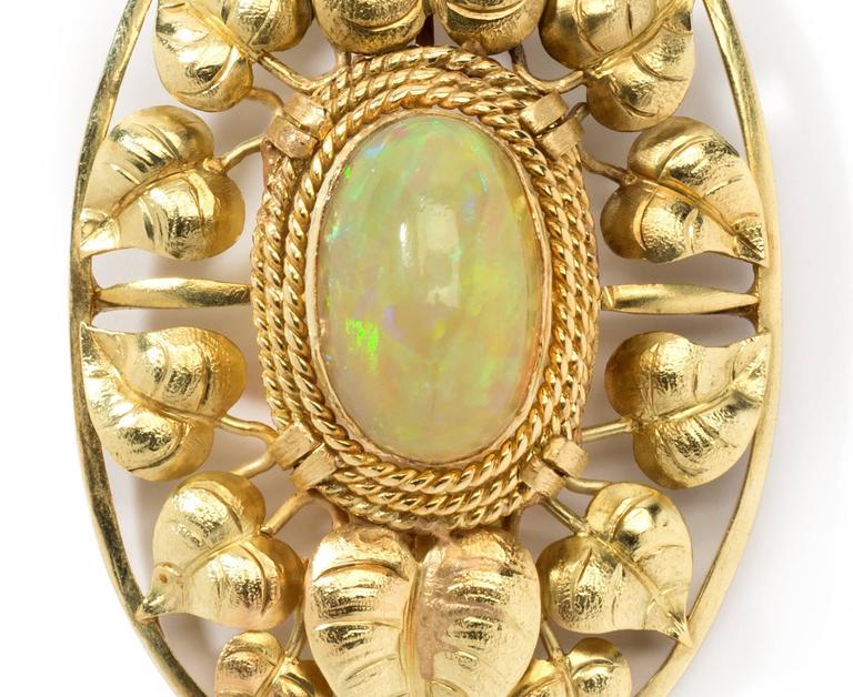 Art Nouveau pendant with 14 K yellow gold chain. By John Zerano, Germany. Opal in cabochon-cut and 2 diamonds weighing approximately 0,10 carats. Mounted in 14 K yellow gold. Signed on the back: J. Zerano. Overall weight: 16,44 g. 
Dimensions of