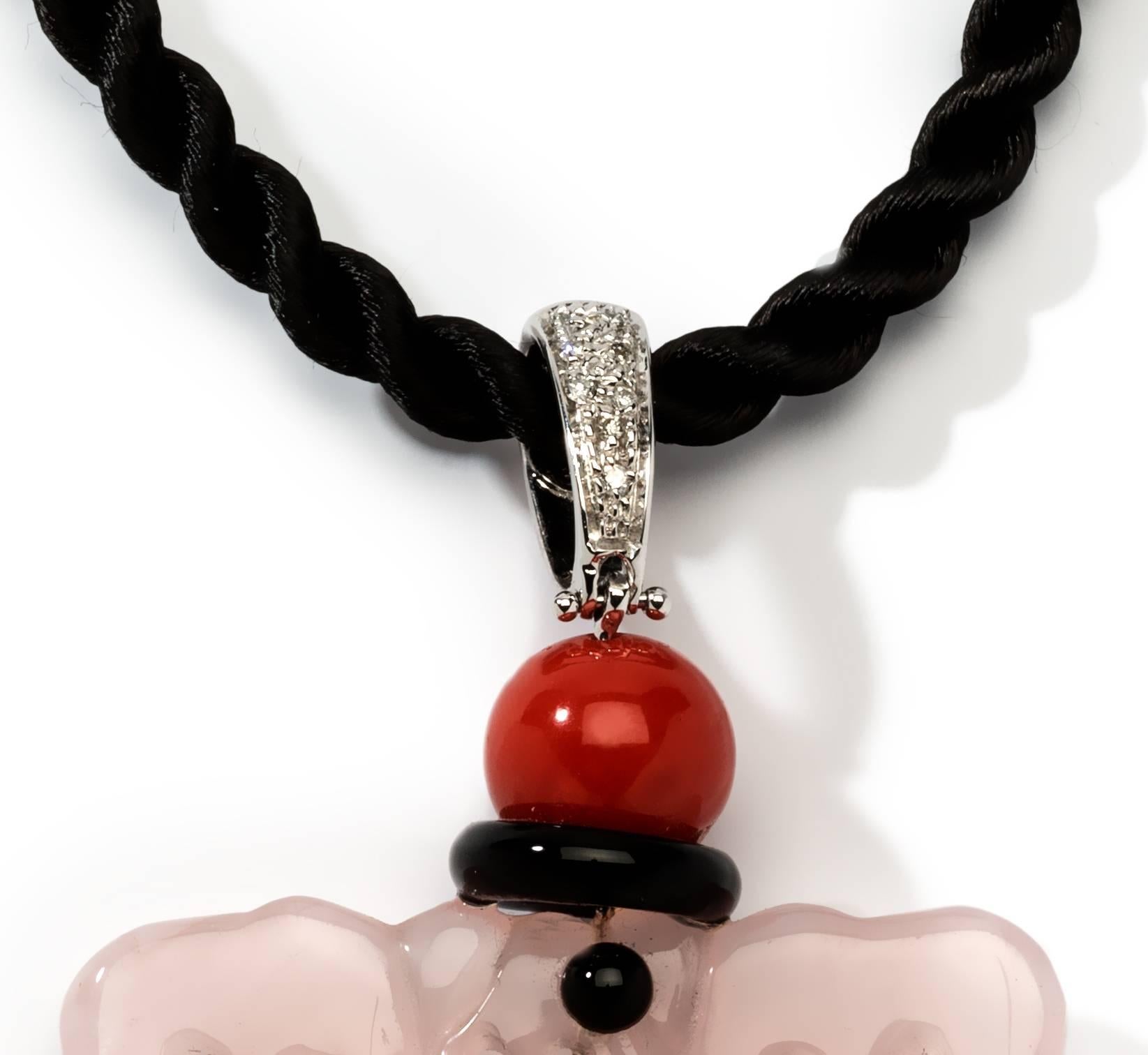 1970's, Italy. Carved light pink jade decorated with onyx and coral. On the loop 8 brilliant-cut diamonds weighing circa 0.06 ct. Mounted in 18K white gold. Hallmarked on the back: Petrosino, star, NA 750. Total weight: 18.03 g. 
Measurements of