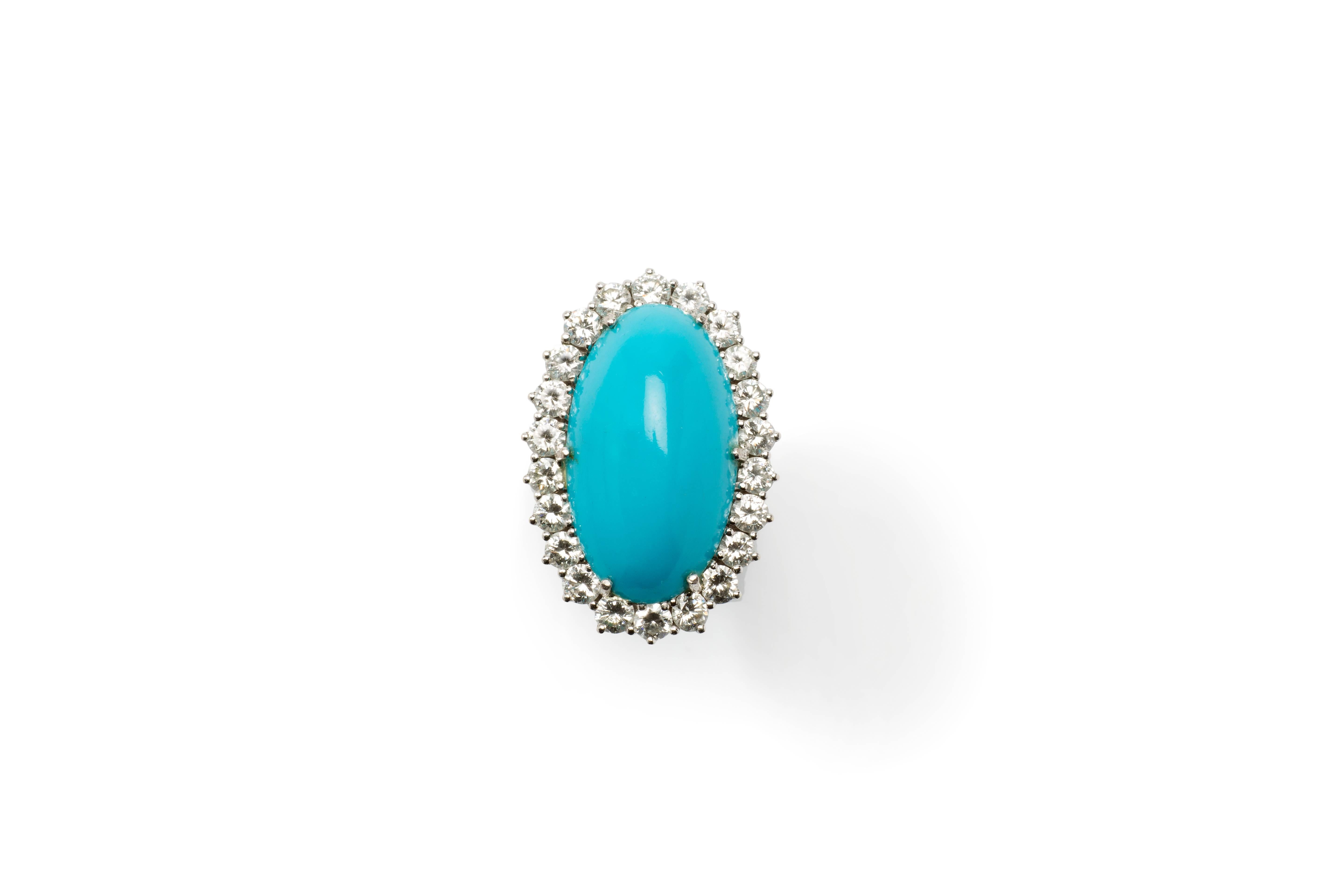 Germany, 1950's. Oval Arizona turquoise in cabochon-cut. Measurements are: 0.95 x 0.55 in ( 24,09 x 14 mm ), 
Height 0.29 in ( 7,41 mm ). Surrounded by 22 brilliant-cut diamonds with a total weight of ca. 2,64 ct. 
Mounted in 14 K white gold.