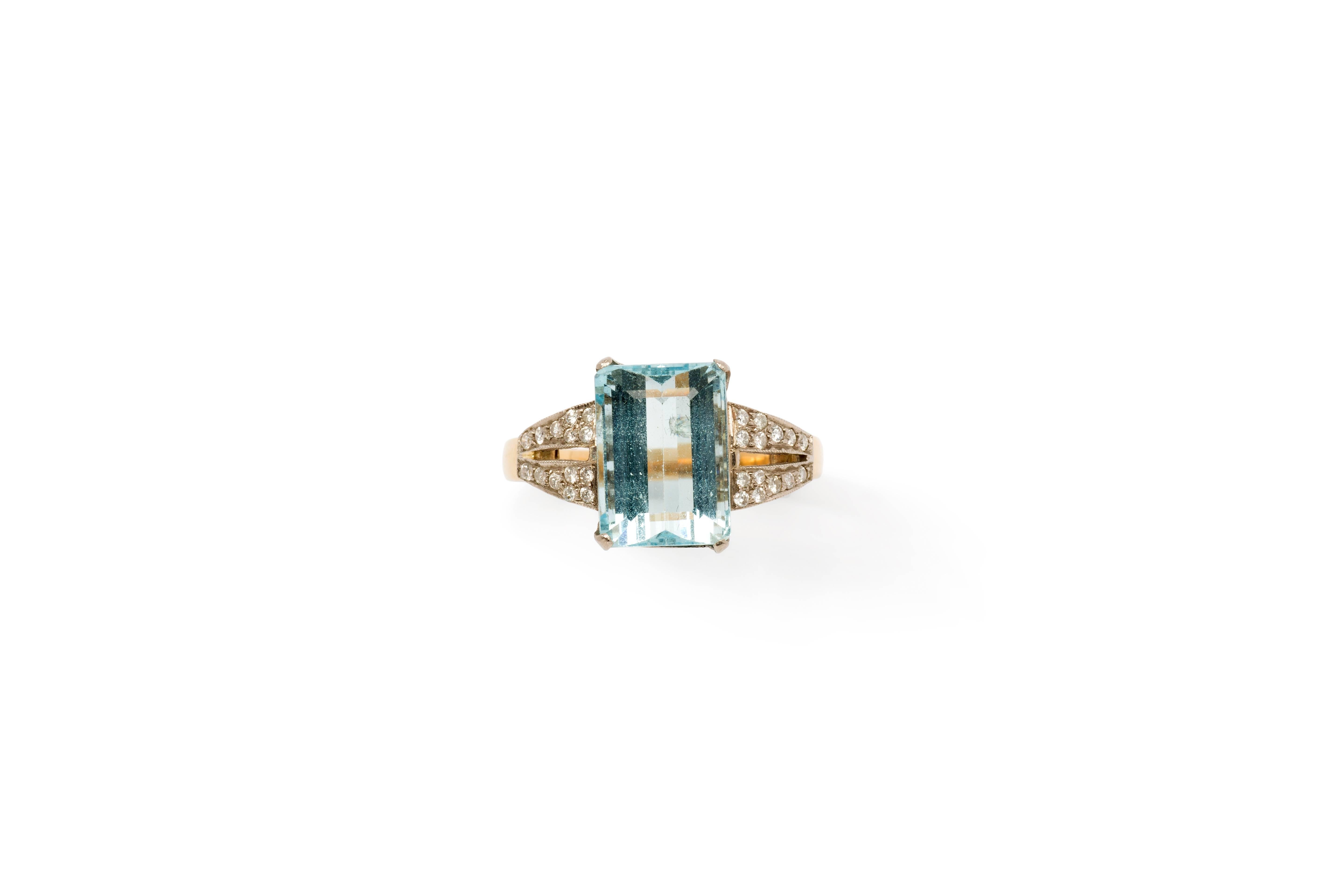 Emerald-cut aquamarine weighing approximately 5,05 ct. Measurements are: 0.49 x 0.35 in ( 12,43 x 8,99 mm ), height: 0.26 in ( 6,72 mm ). 
In a 18 K yellow- and white gold mounting. With 28 brilliant-cut diamond shoulders with a total weight of ca.