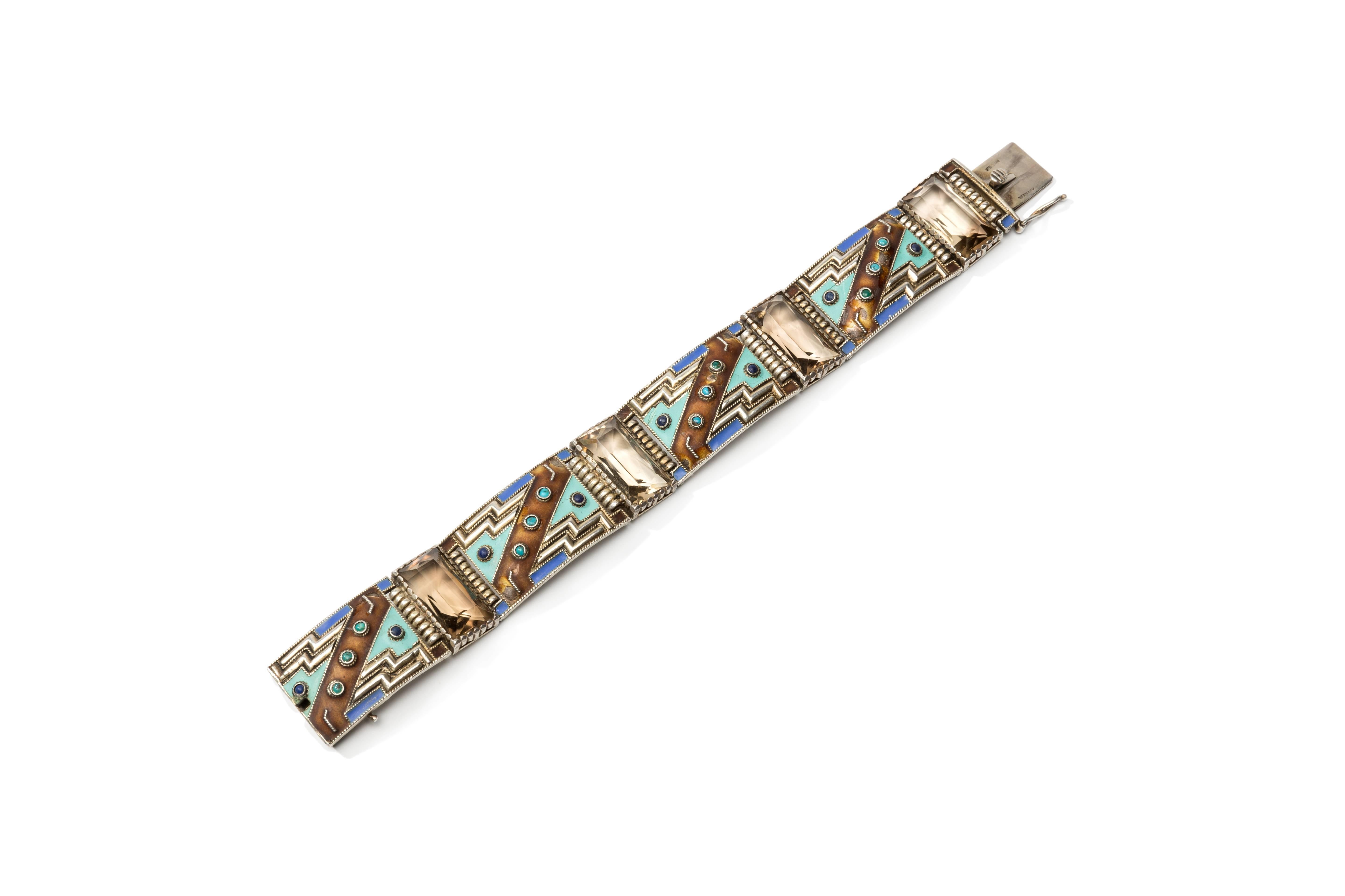 Designed and made by Theodor Fahrer, Germany 1928. 4 enamel panels decorated with 4 smoky topaz, 8 lapis lazuli and 12 Turquoise. Gilded silver. On the clasp marked: STERLING, GERMANY. Total weight: 57,17 g. Length: 7.17 in ( 18,2 cm ). Width: 0.83