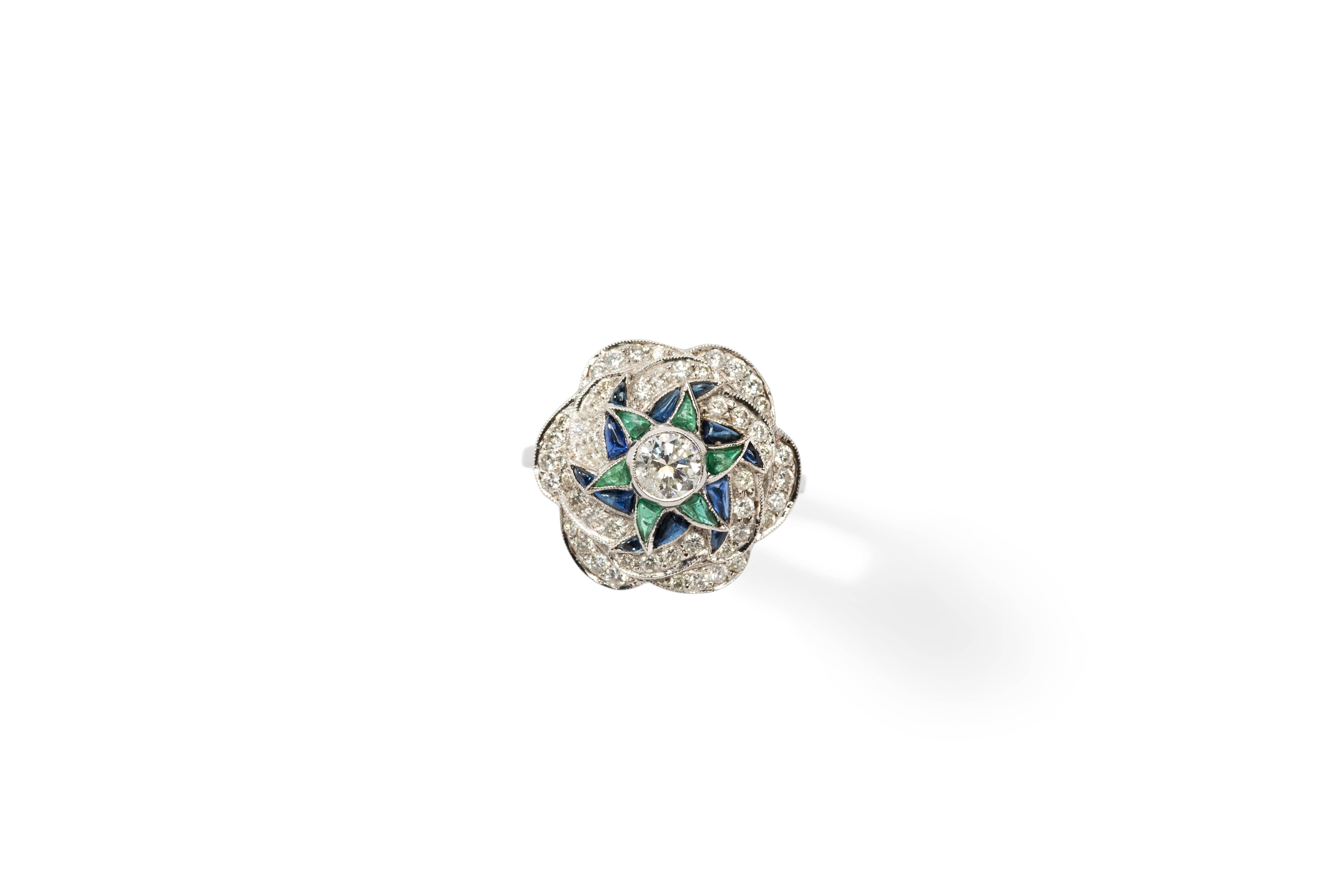 Europe, late 20th century, Art Déco style. Flower shape. Set with 51 brilliant-cut diamonds weighing circa 1.25 ct. Central brilliant-cut diamond circa 0.40 ct. clarity: VVS2, color: fancy light yellow. 12 sapphires weighing circa 0.50 ct. and 6