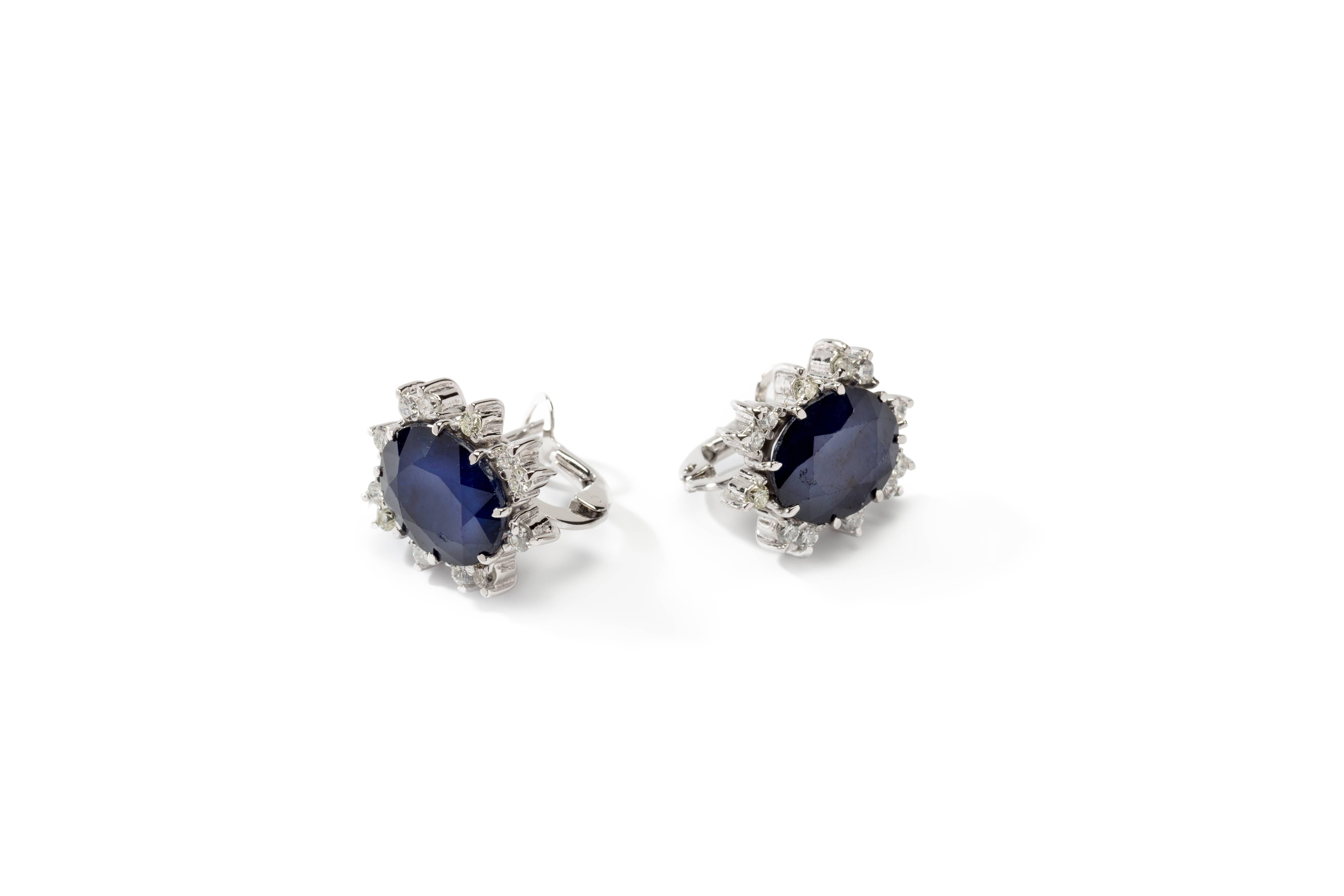 Set with two Australian blue sapphires surrounded by 24 brilliant-cut diamonds weighing circa 0,68 ct. Mounted in 18K white gold. Marked with the purity 750. Total weight: 7,4 grams. Measurements: 0.67 x 0.59 in ( 1,7 x 1,5 cm )

