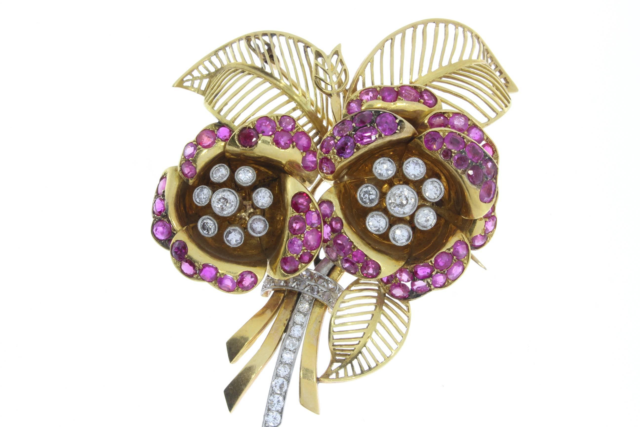 Flower-shaped brooch, decorated with 72 rubys totaling circa 7.0 ct., and 37  diamonds of good clarity, totaling circa 2.50 ct. Mounted in 18 carat yellow- and red gold in millegrain setting. 
Total weight: 54,42 g. Dimensions: 3.07 x 2.44 in ( 7,8