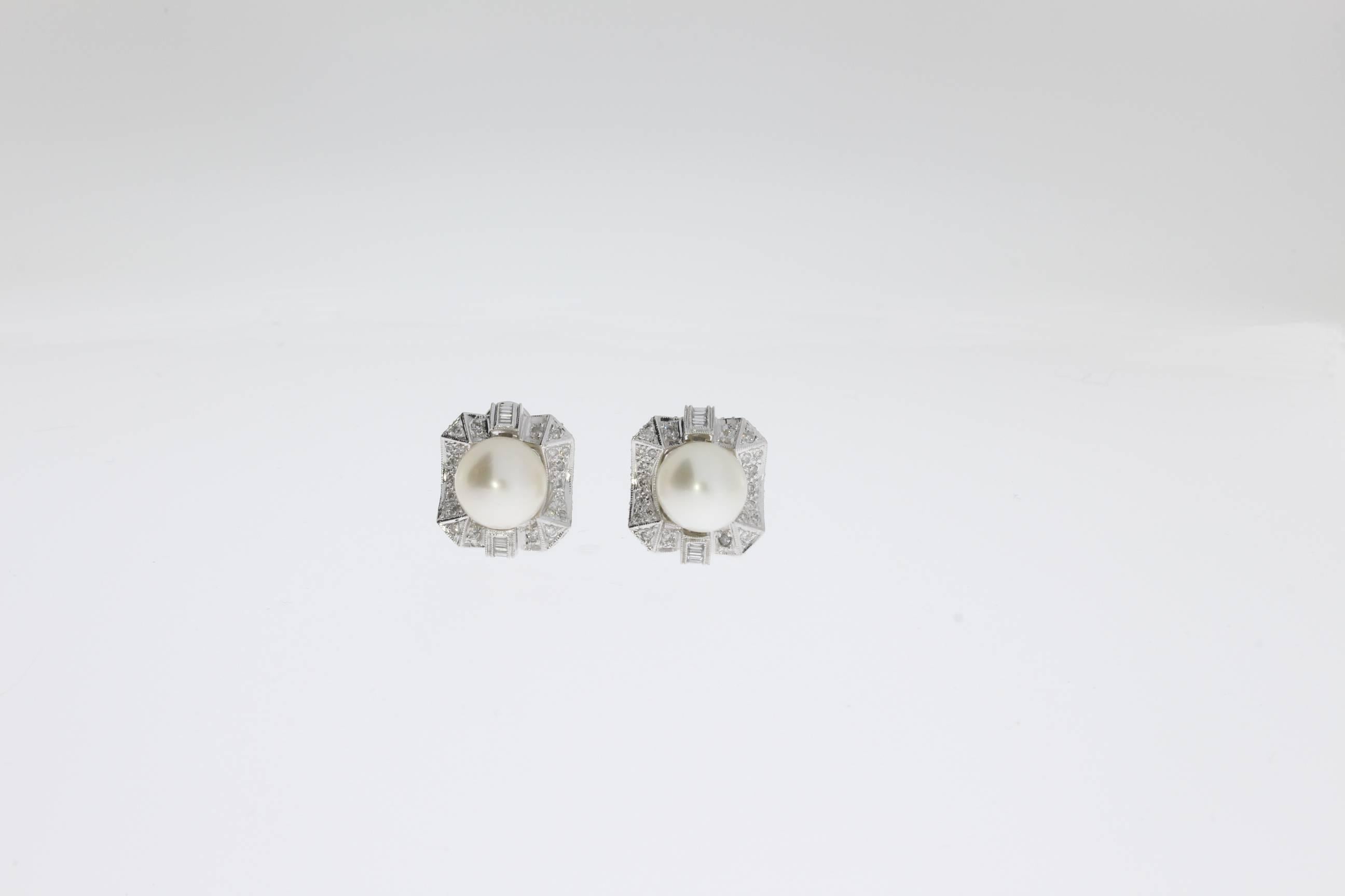 At the centre South Sea pearls measuring 10,43 and 10,58 mm in diameter. Framed by 24 baguette-cut and 104 brilliant-cut diamonds weighing circa 2,12cts. Mounted in 14K white gold. On the back side hallmarked: IX and the purity 14K 585. Total