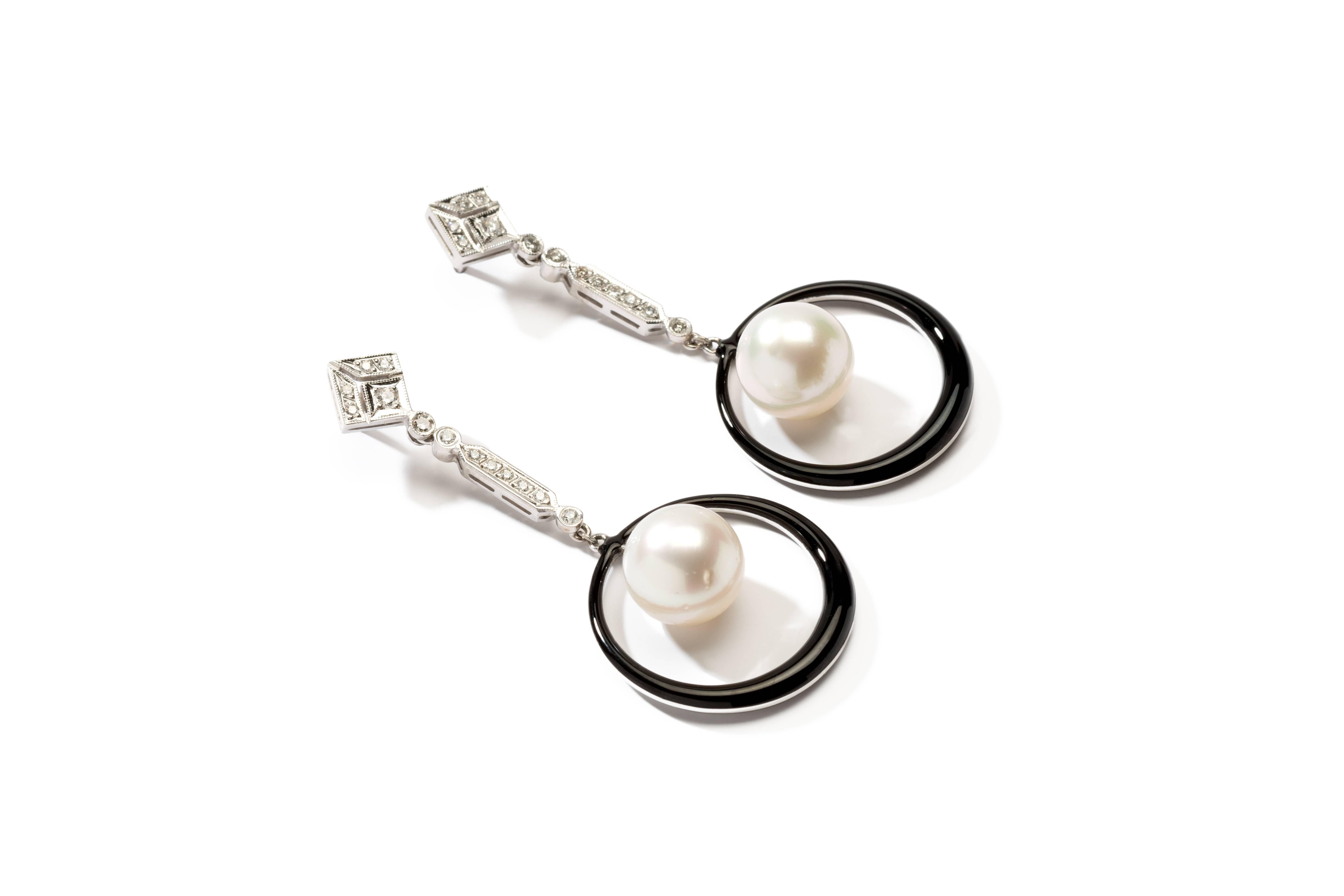 A beautiful set with 2 south sea pearls of ca. 11 mm each and 26 brilliant-cut diamonds weighing approximately 0,60 ct. Black enamel rings as a contrast. Mounted in 18 K white gold in a millegrain setting. Total weight: 12,55 g.
Length: 2.17 in (