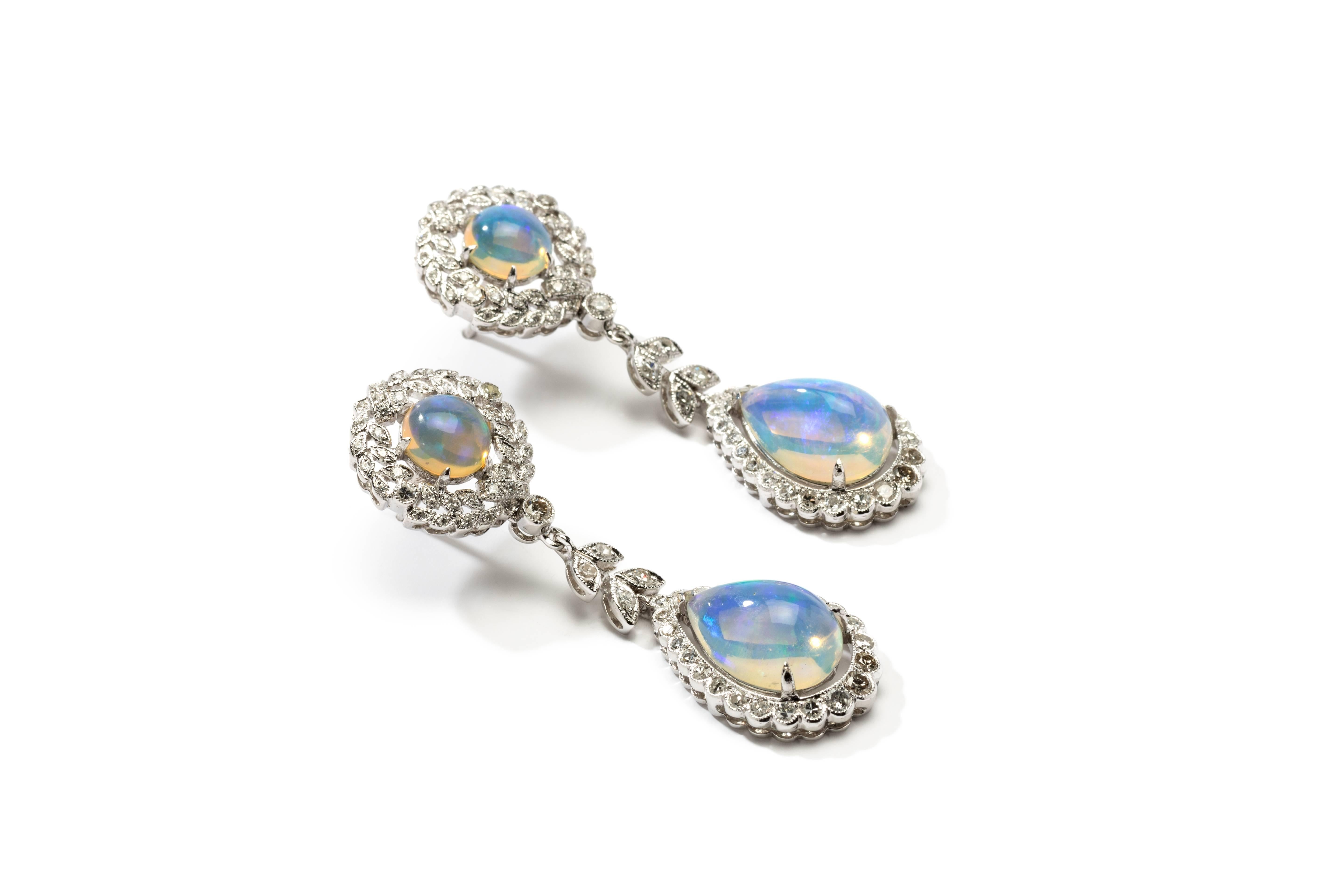 Set decorated with an 2 round- and 2 teardrop-shaped opal bordered by 192 diamonds and brilliant-cut diamonds weighing circa 1,57 ct. Mounted in 18 K white gold. Millegrain setting. On the back each hallmarked with the purity 750. Total weight: 9,86