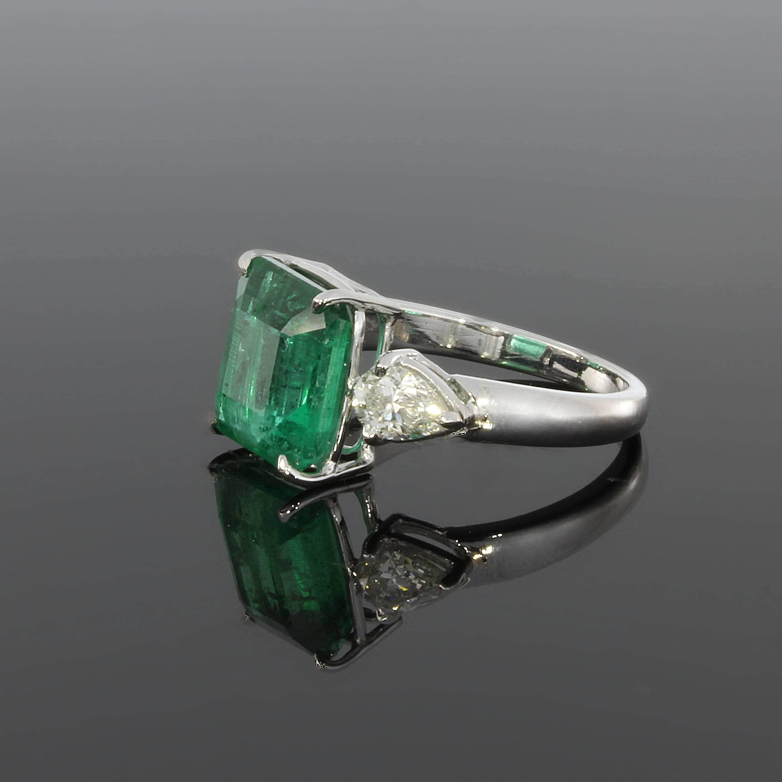 Colombian emerald ( 5.30 ct. ) flanked by two drop-cut diamonds ( Tot. 0.92ct., clarity: VS1, color: TW ). Mounted in 18 K white gold. Hallmarked inside:  750S, Star, SP. Total weight: 5,59 g. Ring size: 57 ( US 7 3/4 ). Resizable
Measurements: