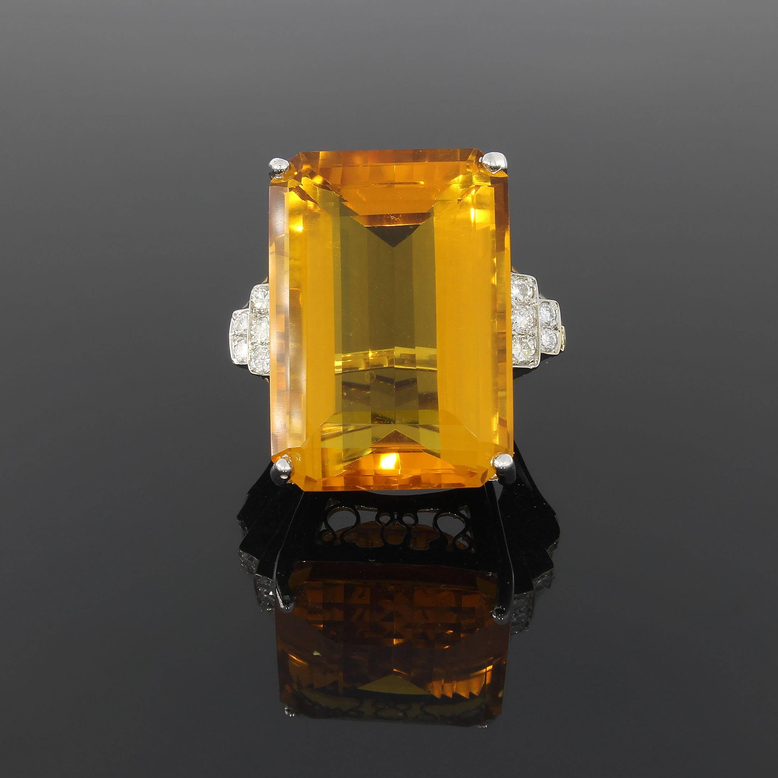  Large emerald-cut citrine weighing ca. 22,8 ct. Flanked by 12 brilliant-cut diamonds weighing totaly 0,60 ct. 
Total weight: 22,76 grams. Measurements: 1.18 x 0.87 in ( 3 x 2,2 cm ). Height: 0.63 in ( 1,6 cm ) 
Ring size: 55 ( US 7 1/3 ). Resizable
