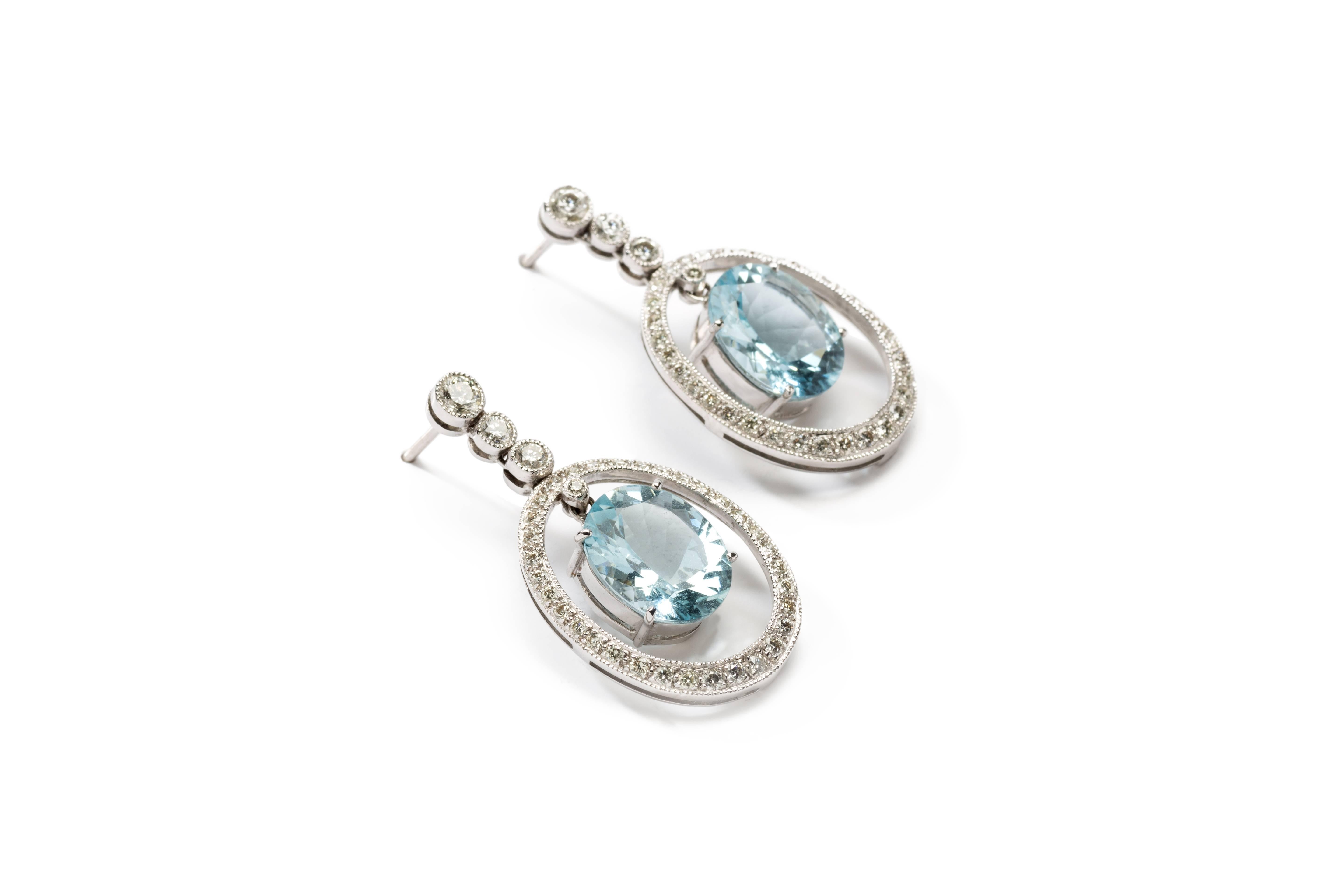 Each earring with an oval aquamarine, totaling circa 7.80 ct. Surrounded by 74 brilliant-cut diamonds 
with a total weight of ca. 1,20 ct. Mounted in 18 K white gold. Millegrain setting. Overall weight: 7,3 g. 
Length: 1.26 in ( 3,2 cm ), Width: