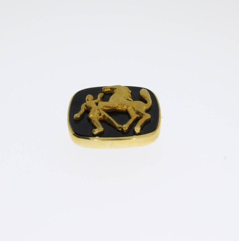 Set with 14 K yellow gold image of horse and rider on onyx board. Onyx frame in prong setting, encircling golden border. Total weight: 16,23 g. Measurements: 0.91 x 1.18 in ( 2,3 x 3 cm )