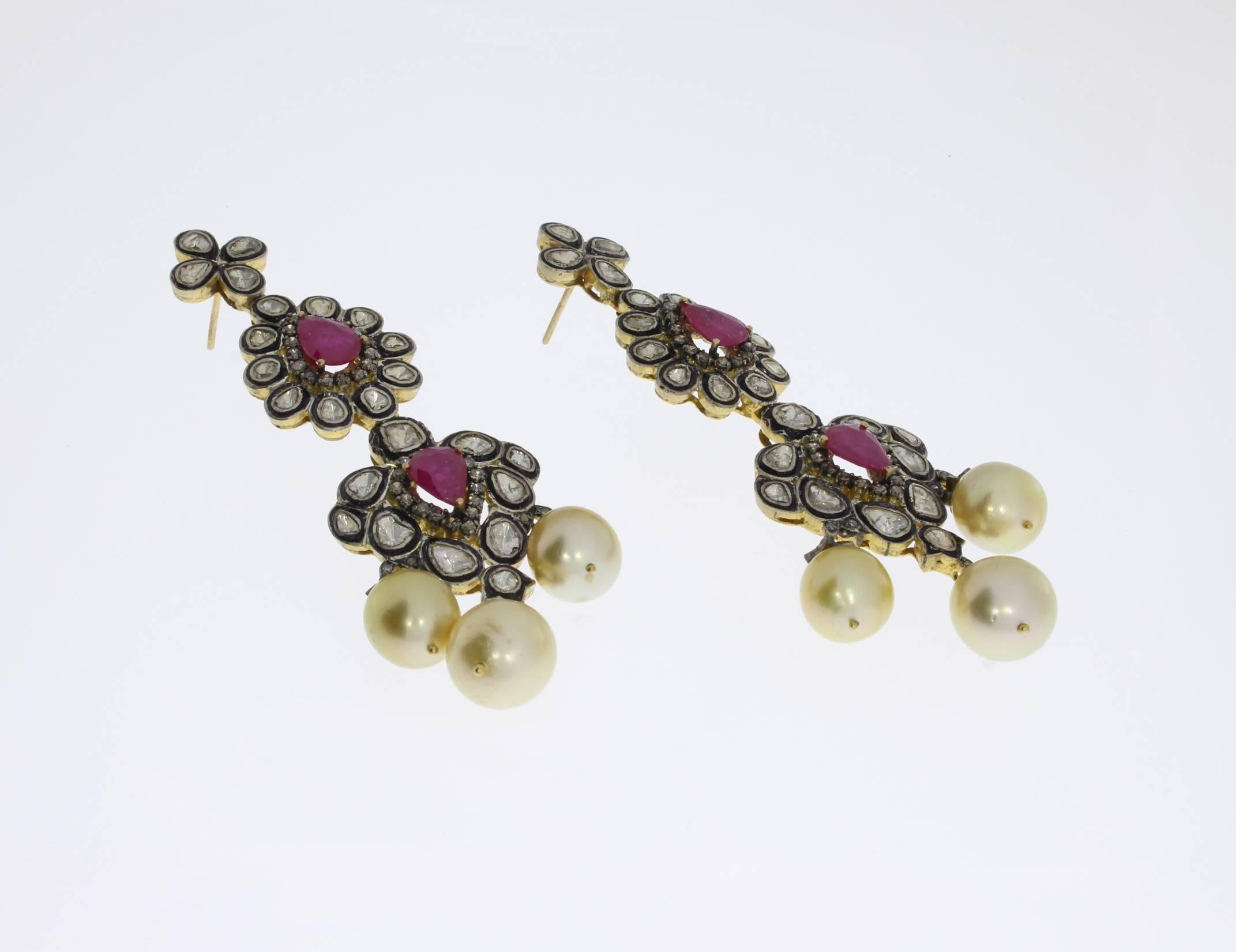 Oriental earrings, design about 1900 with 48 diamonds of circa 9,5 ct. total, 4 tear-drops rubies and 6 South Sea pearls with 10-11 mm in diameter. Mounted in 14 K gold and sterling silver. Total weight: 42,41 g. Length: 3.35 in ( 8,5 cm )
