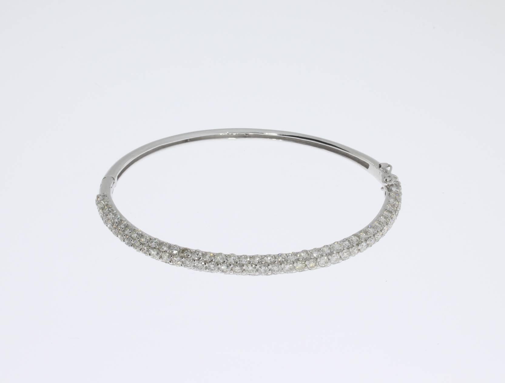 18 K white gold bangle bracelet with three rows of 115 brilliant-cut diamonds weighing 4,60 ct., color TW. Total weight: 10,99 g. New, unworn. Dimensions: 2.2 x 2.44 in ( 5,6 x 6,2 cm )