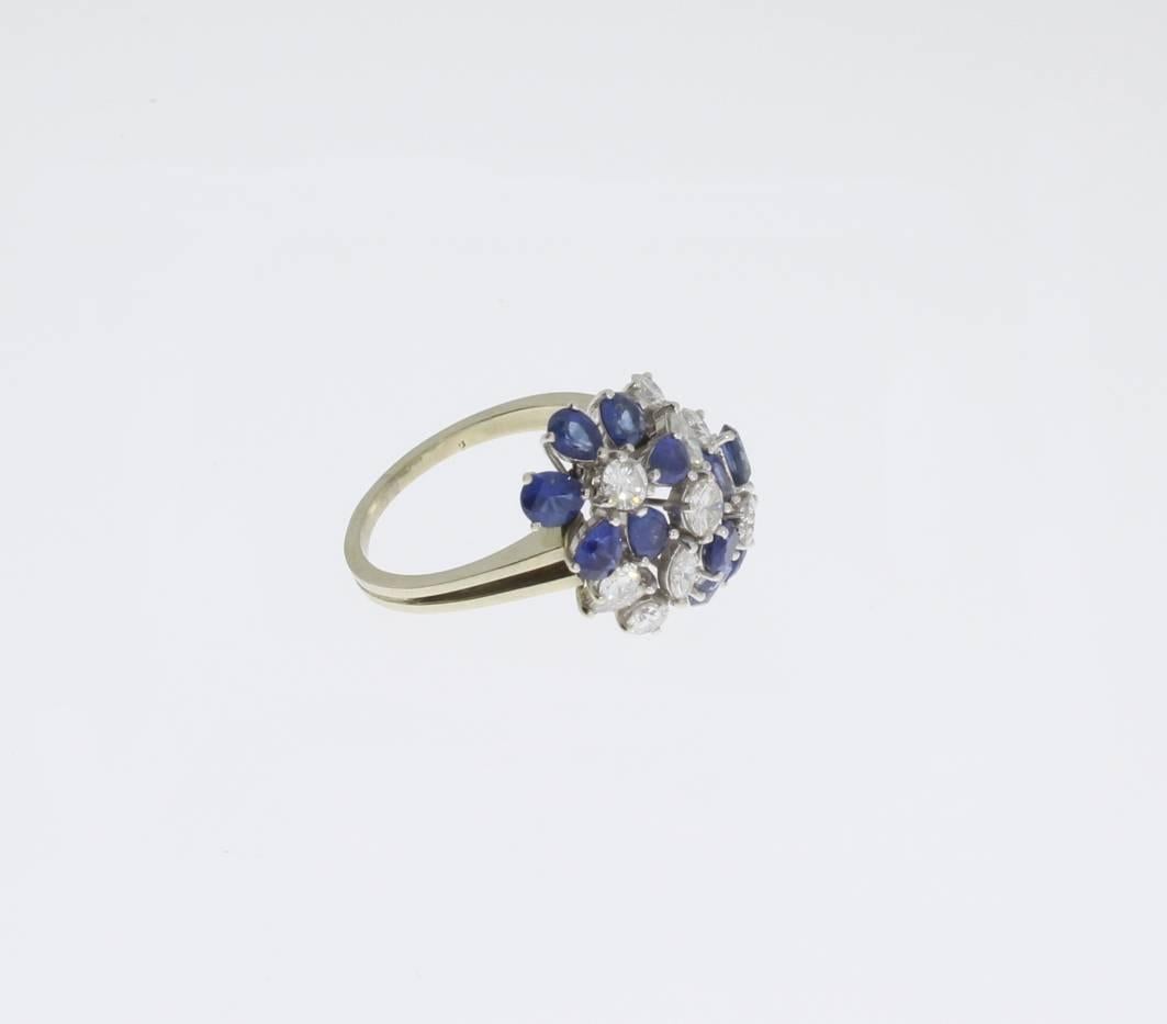 Europe 1960s. Floral shaped set in 18 K white gold with 12 sapphires weighing circa 2,6 ct., 7 brilliant-cut diamonds and 4 navette-cut diamonds, color TW, clarity VVS1. Total weight: 5,09 g. Dimensions: 0.87 x 0.67 in ( 2,2 x 1,7 cm ). Ring size: