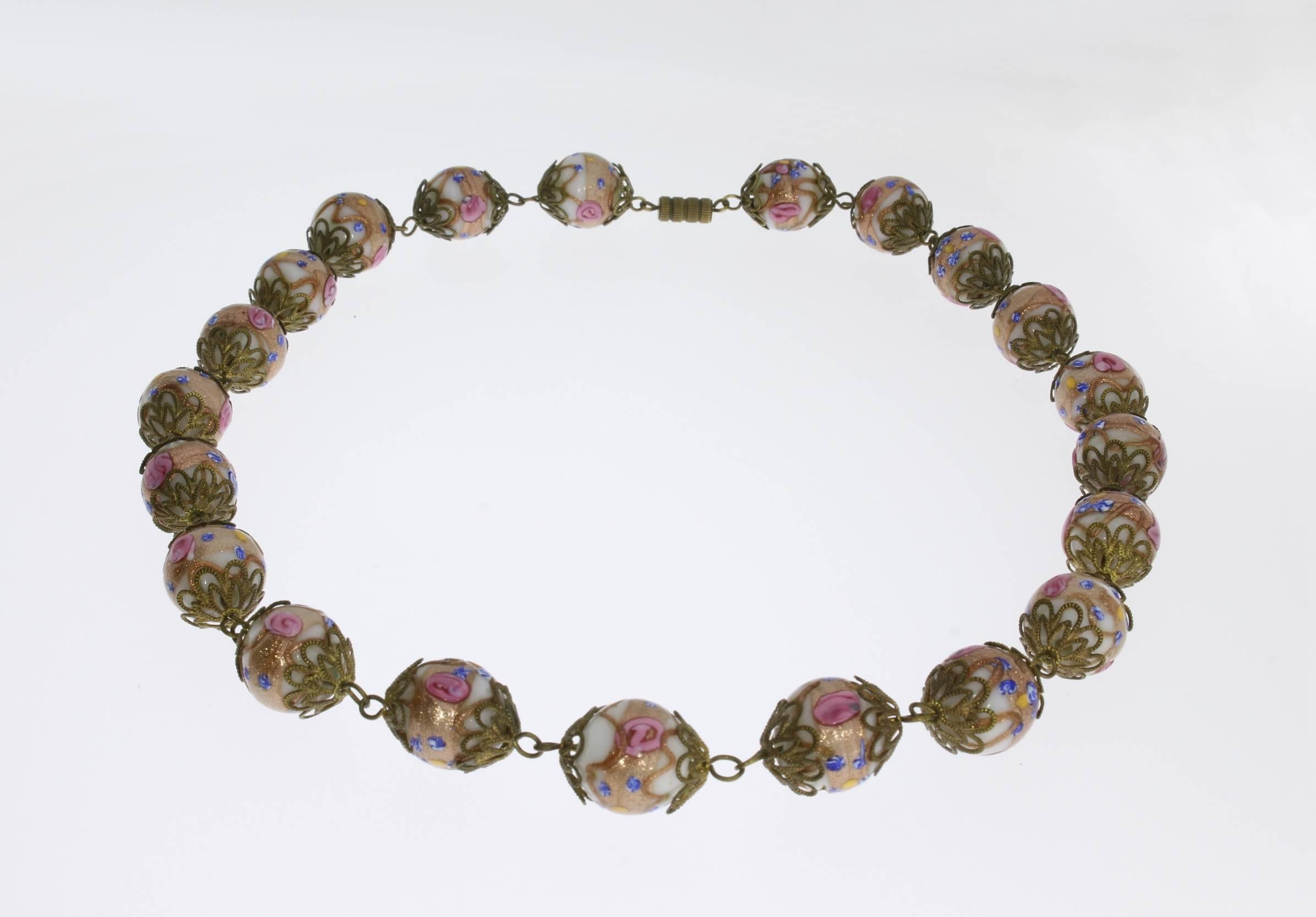 Original collector's item. Handcrafted.
Murano, Italy around 1930-1940. With 21 glass beads in white, gold, yellow, pink and blue. In lampwork technique ( millefiori ). Each bead decorated by metal-rosette. The diameter of each bead is approx. 0.63