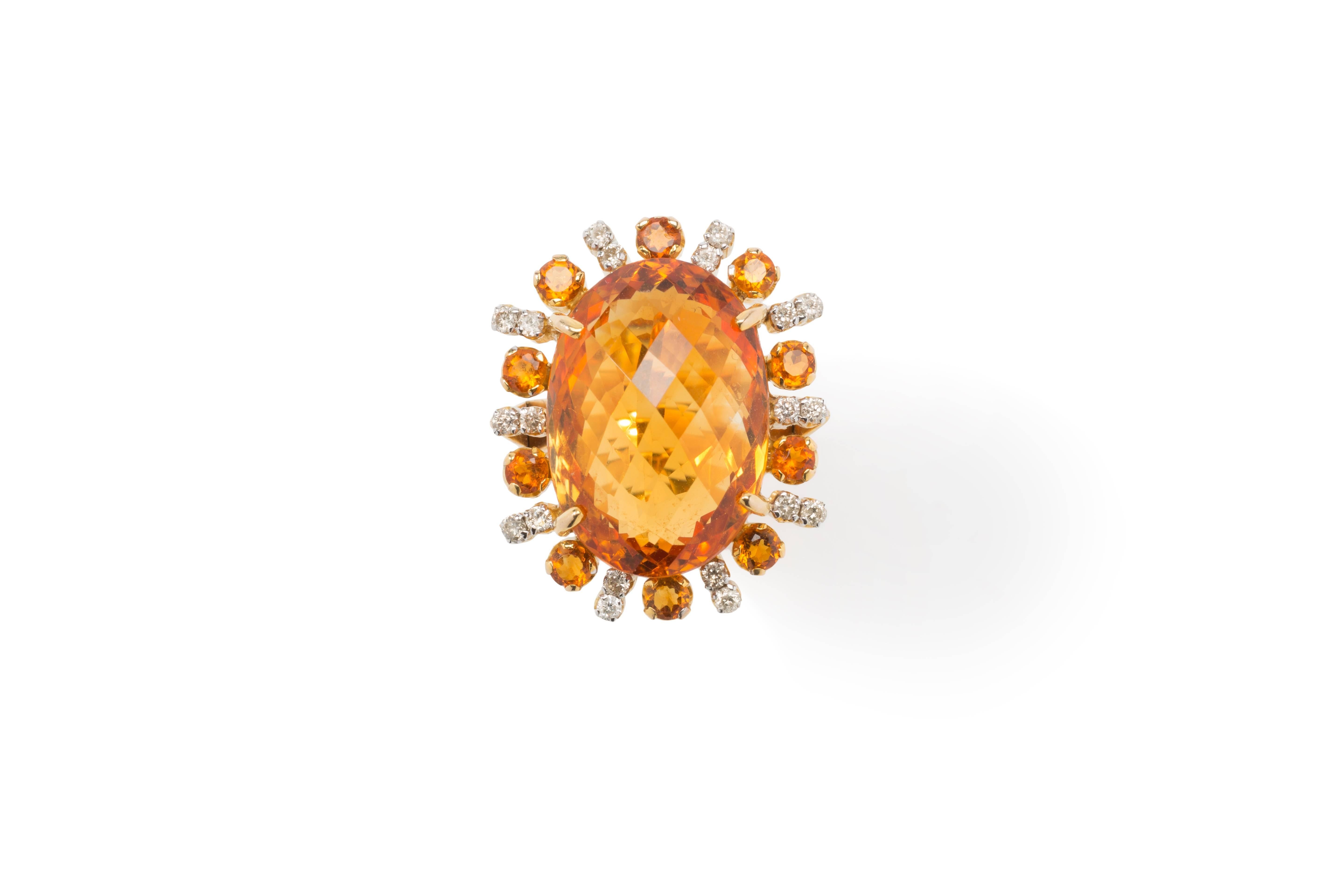 Impressive 18 carat yellow gold ring. The large oval shaped and faceted Madeira topaz surrounded by 10 small topazes and 20 brilliant-cut diamonds weighing circa 0,40 ct. Total weight: 16,38 g. 
Measurements: 1.18 x 0.94 x 0.63 in ( 3 x 2,4 x 1,6 cm