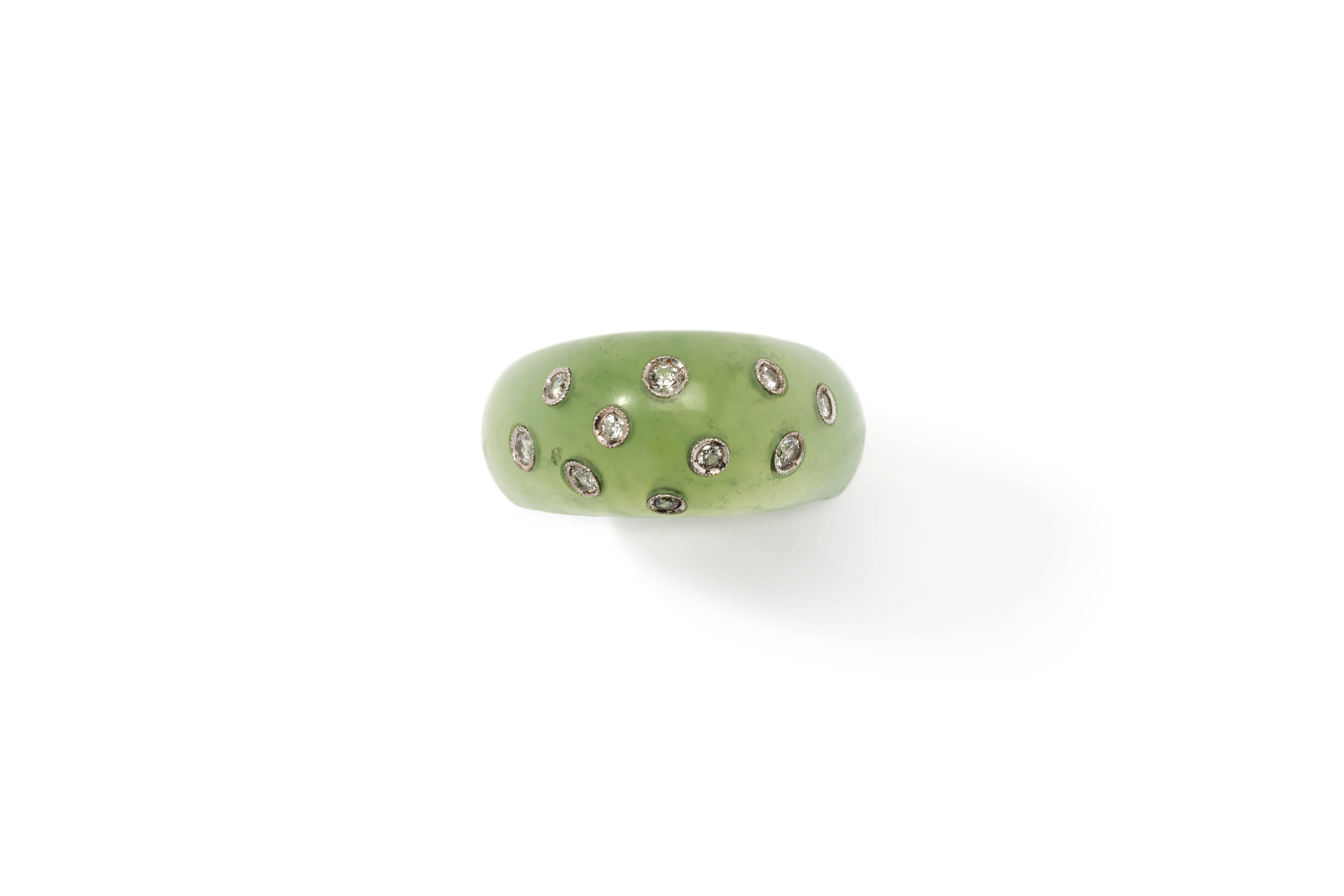 Italy, 1970s. Light green tone jade. Decorated by 10 brilliant-cut diamonds mounted in platinum with a total of ca. 0,40 ct. Millegrain setting. 
Total weight: 7,85 grams. Height: ca. 0.39 in ( 1 cm ), Width: 0.51 in ( 1,3 cm ). Ring size: 59 ( US
