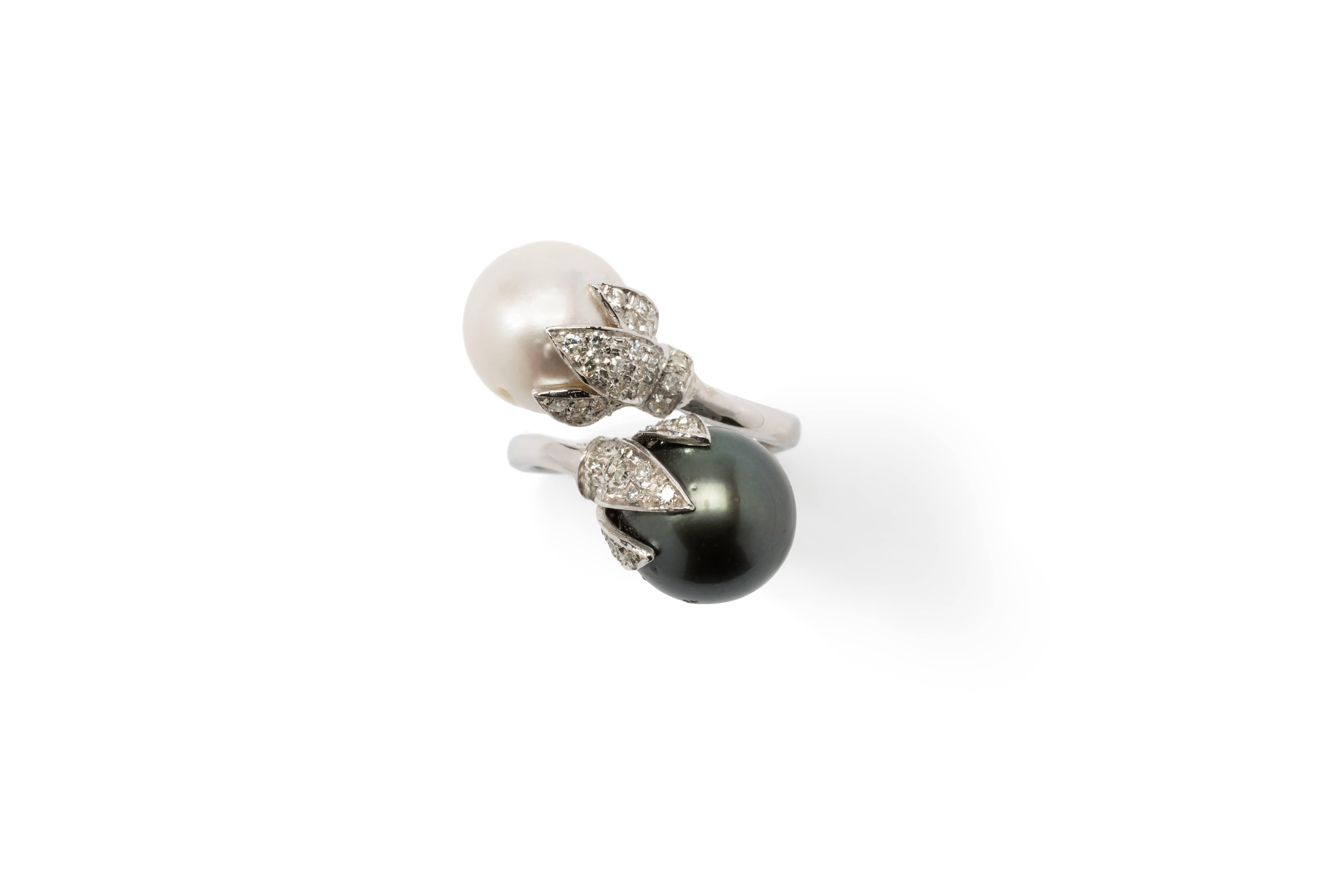 Set with South Sea white pearl and Tahitian black pearl measuring 0.47 in ( 1,2 mm ) in diameter. Decorated by 52 brilliant-cut diamonds. Mounted in 14 K white gold. Hallmarked inside with the purity 585. Total weight: 11,33 g. Ring size: 54 ( US