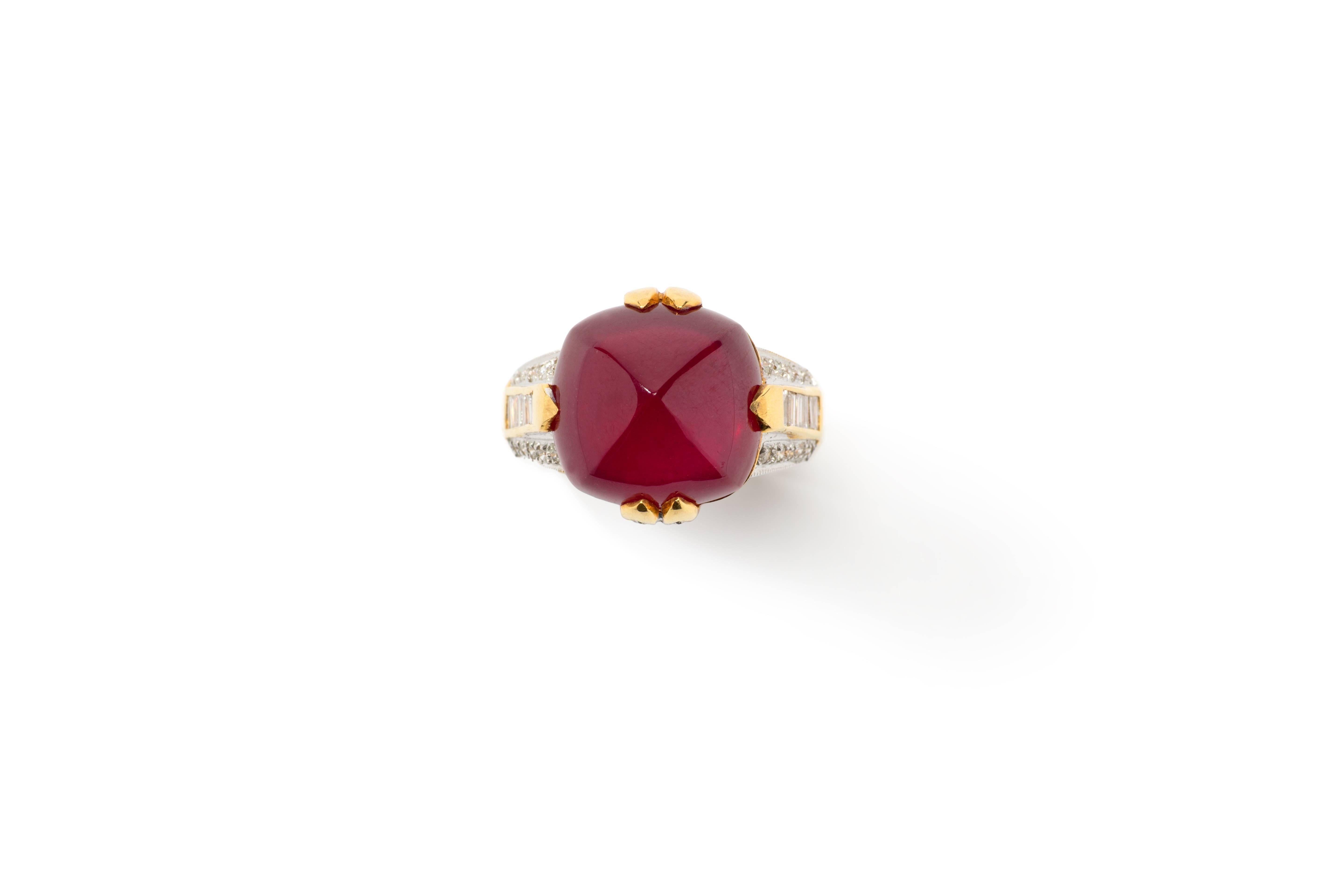 Central sugarloaf ruby weighing 18,78ct. Accompanied by 14 baguette-cut diamonds with a total weight of ca. 0,42ct and 28 brilliant-cut diamonds with a total weight of ca. 0,38ct. Mounted in 18 K yellow gold.Hallmarked inside with the purity 18K.