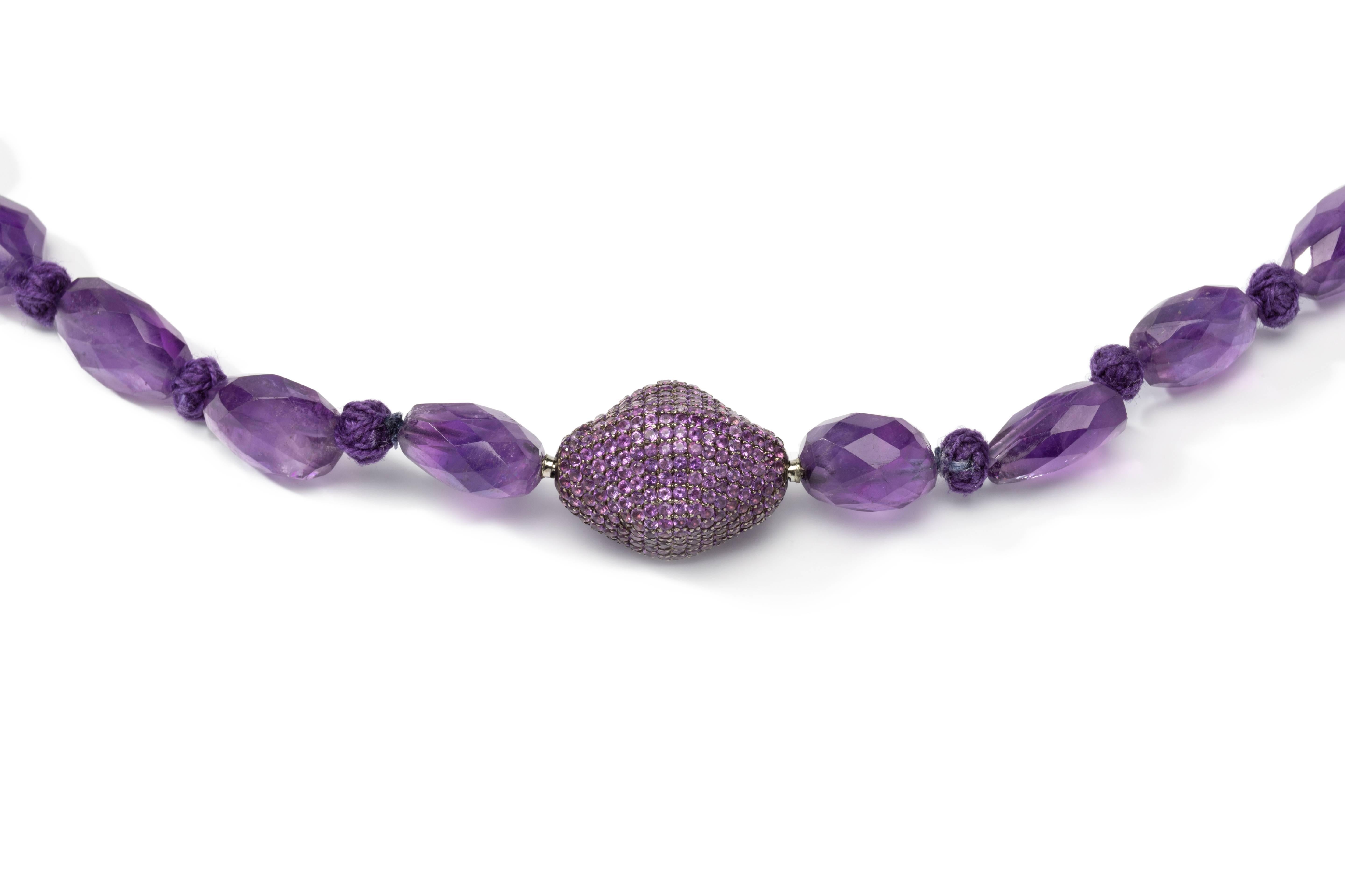 Single strand of 27 faceted purple hue amethyst nuggets. Twitted on purple yarn. With a decorative silver and steel clasp of pavé amethysts with a total weight of 6,65 ct. Total weight: 105,4 grams. Lenght: ca. 12.01 in ( 30,5 cm )