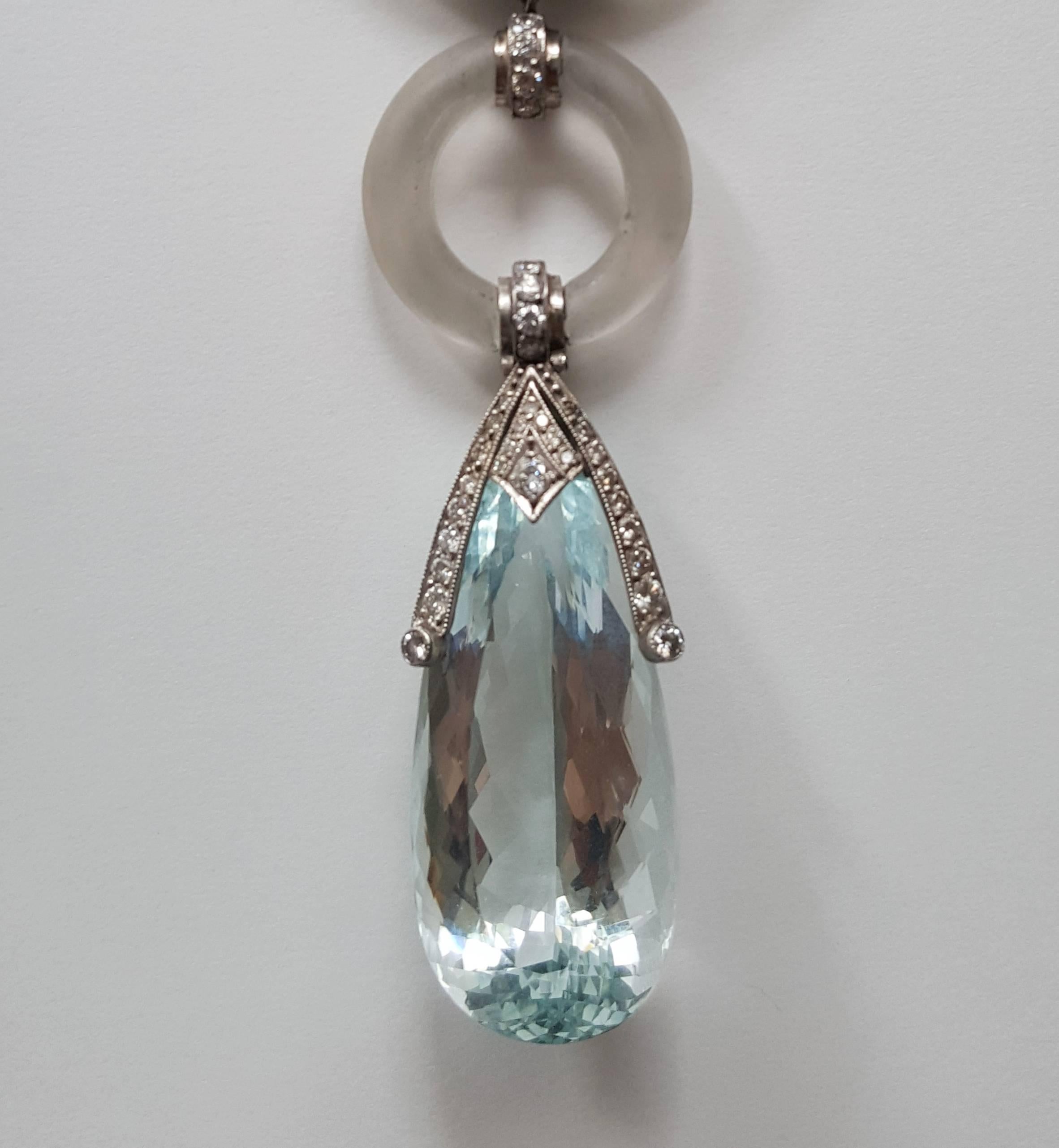 A real eye-catcher set with large drop shaped aquamarine with a weight of circa 26,0 ct., 59 brilliant-cut diamonds weighing ca. 1,88 ct. and 2 satin-finished rock crystal rings. Mounted in platinum. With 18 carat white gold chain. Total weight: