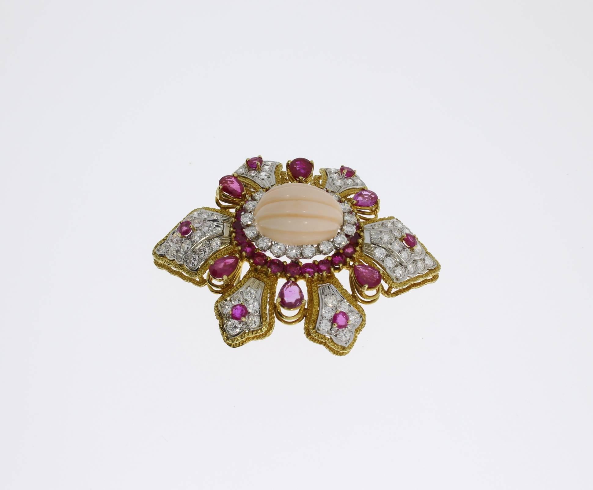 1960s-1970s. Cabochon-cut carved coral, 76 brilliant-cut diamonds weighing approximately 5,30 ct., 32 rubies weighing circa 8.70 ct. Mounted in 18 K yellow gold. Hallmarked with the fineness 750. Total weight: 32,30 g. 
Diameter: 1.77 in ( 4,5 cm )