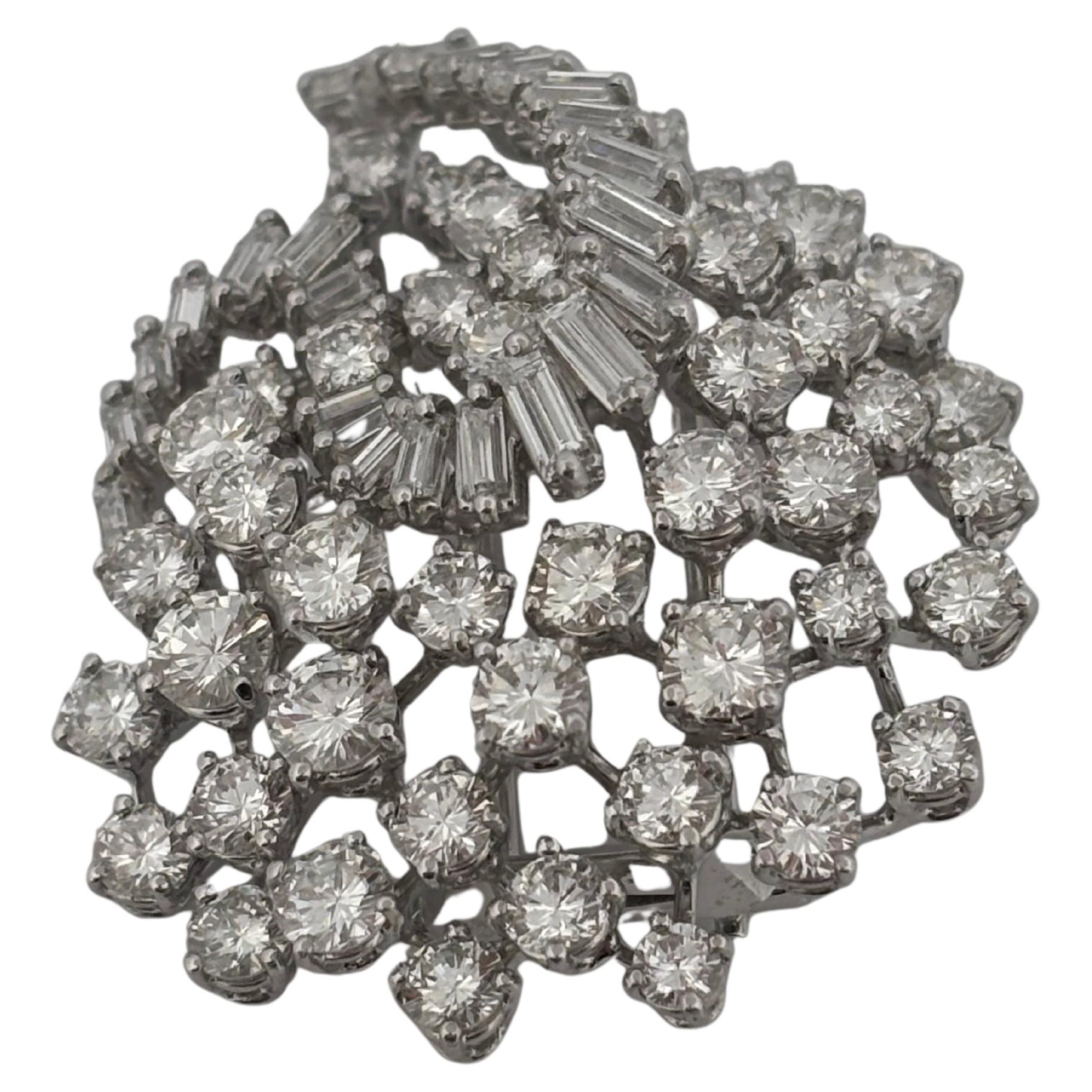 Cette exquise broche pendentif en platine éblouit avec environ 5,00 carats de diamants ronds et baguettes, magistralement disposés dans un design dynamique d'inspiration florale. Une combinaison frappante de diamants ronds de taille brillante et de