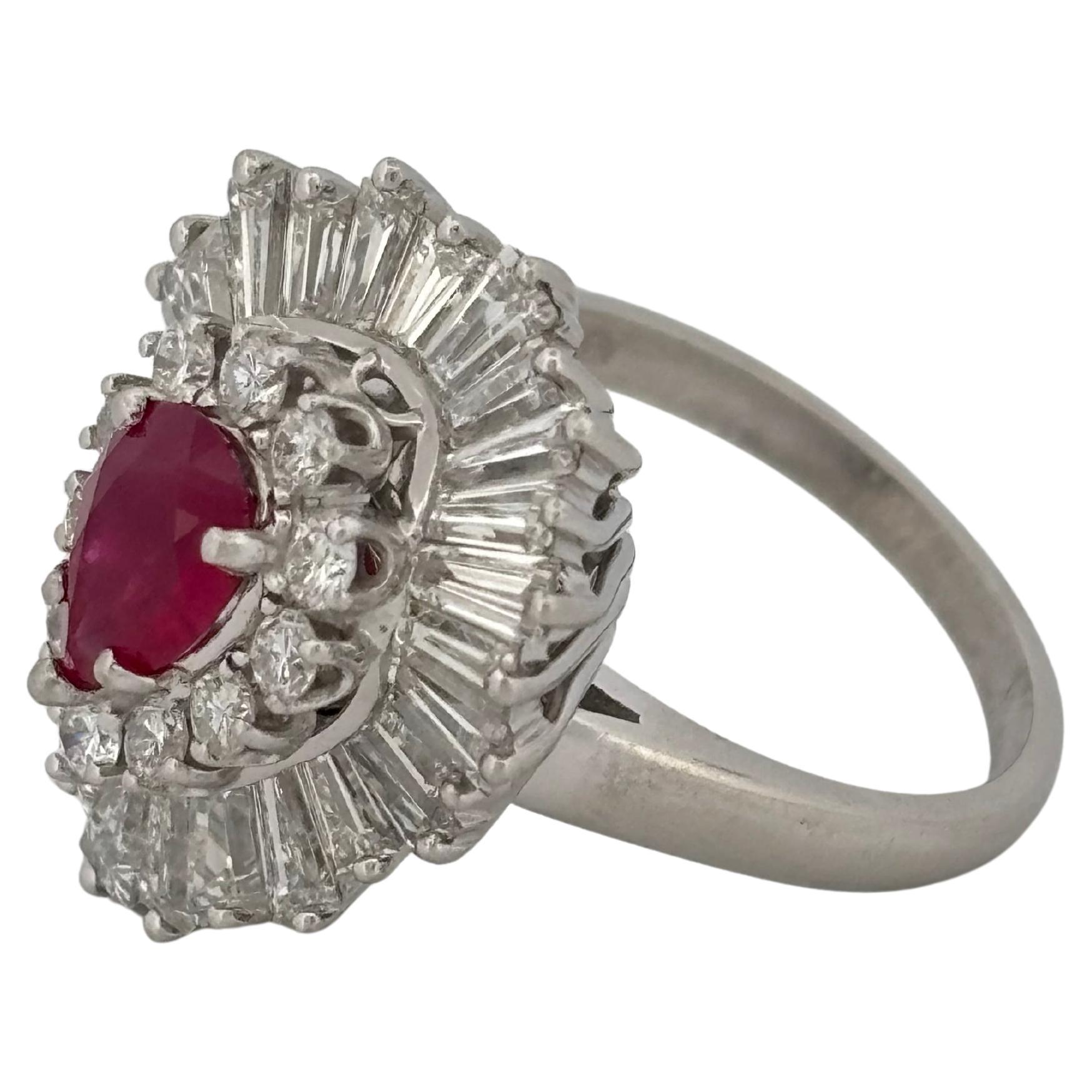 This striking vintage jewel serves as both a ring and a pendant, offering versatility and timeless elegance. 
at its center is a richly colored, pear-shaped ruby framed by a halo of round brilliant-cut H-I SI1-SI2 diamonds and a dramatic outer tier