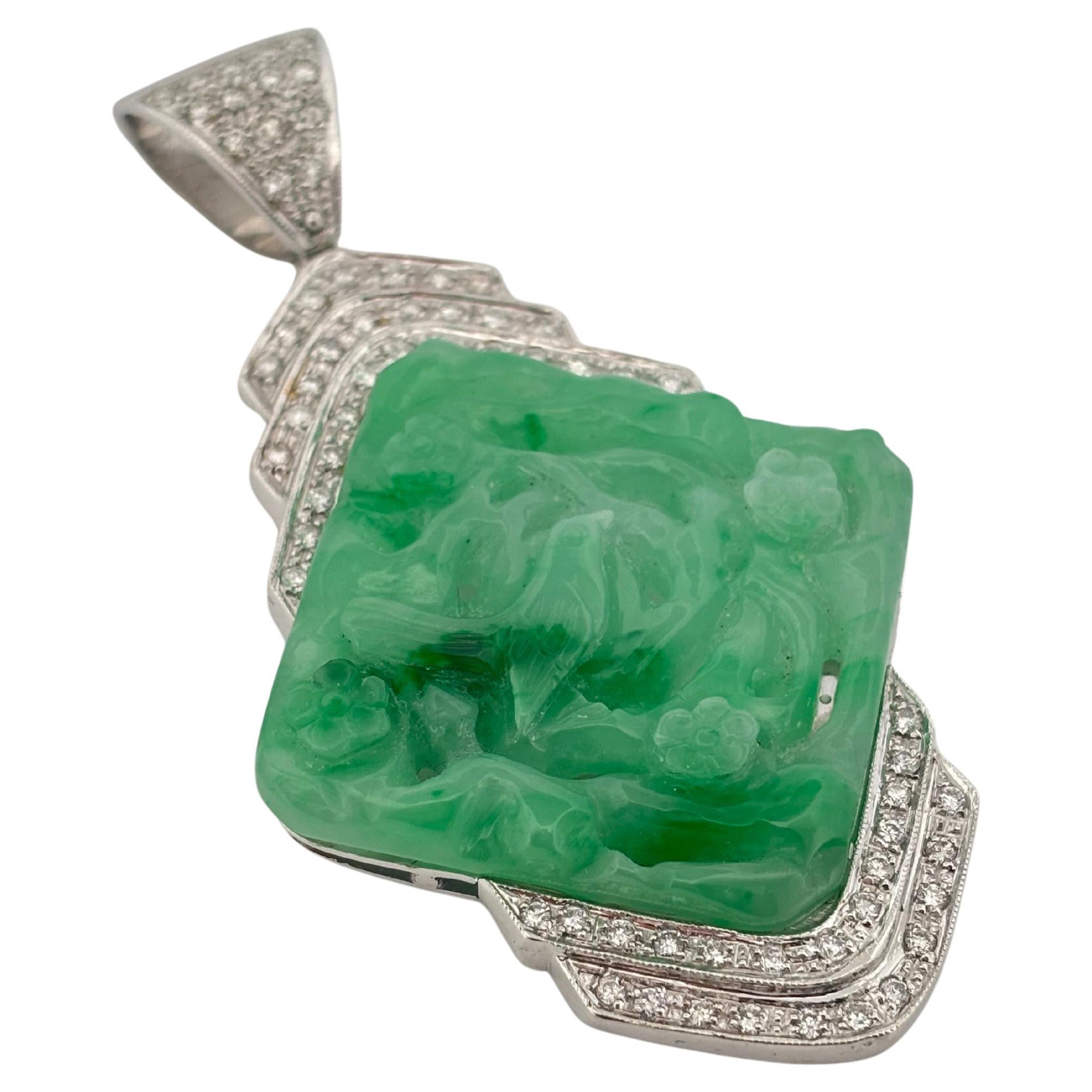 This elegant vintage pendant showcases a hand-carved jade plaque set in luxurious 18K white gold. The rich green jade features intricate floral and foliate motifs, evoking timeless artistry and cultural heritage. Framed by three tiers of brilliant
