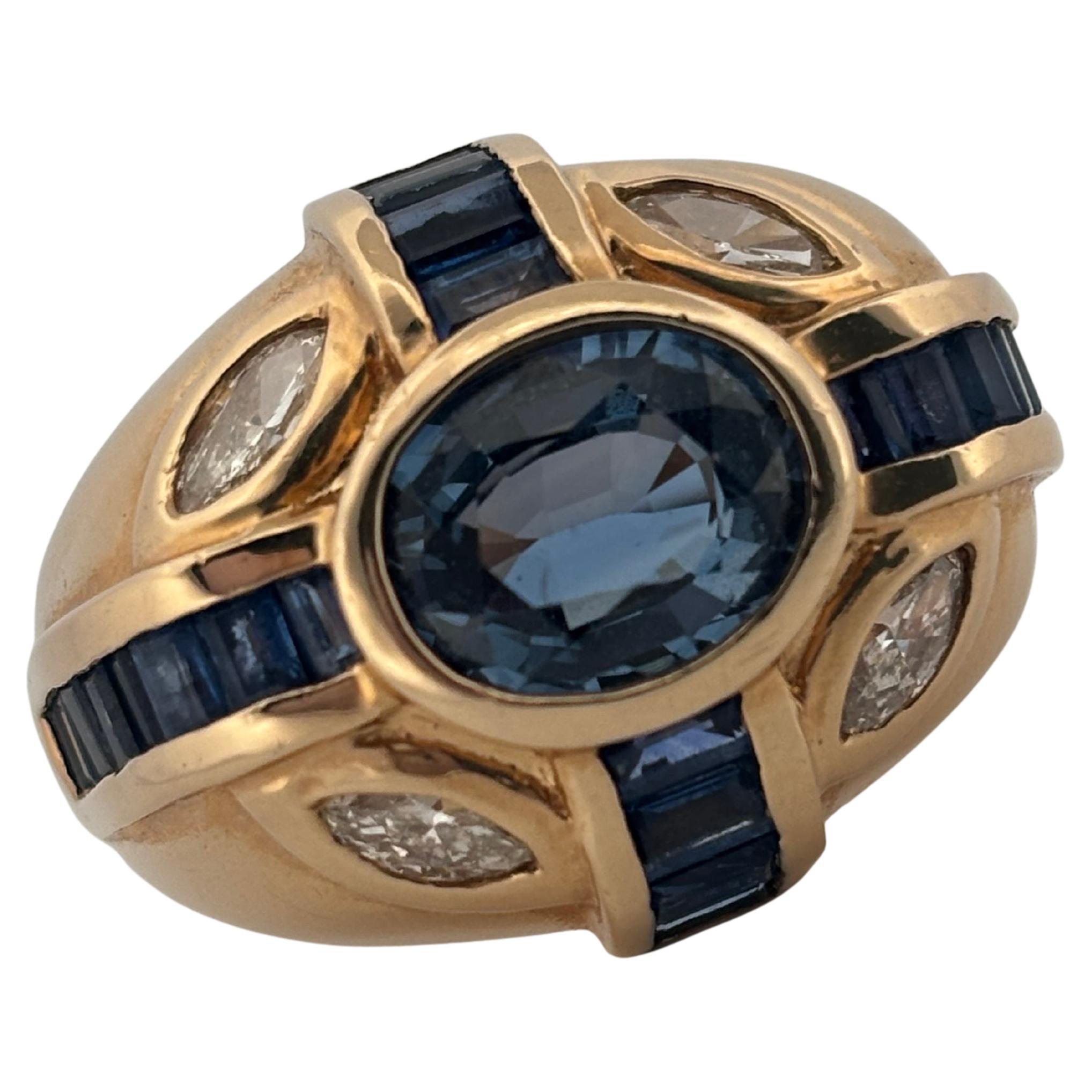 Crafted in rich 14K yellow gold, this bold vintage ring features a captivating oval-cut 2.00 carat blue sapphire at its center, radiating a deep, velvety hue. The sapphire is accented by channel-set baguette sapphires that run along the band, adding