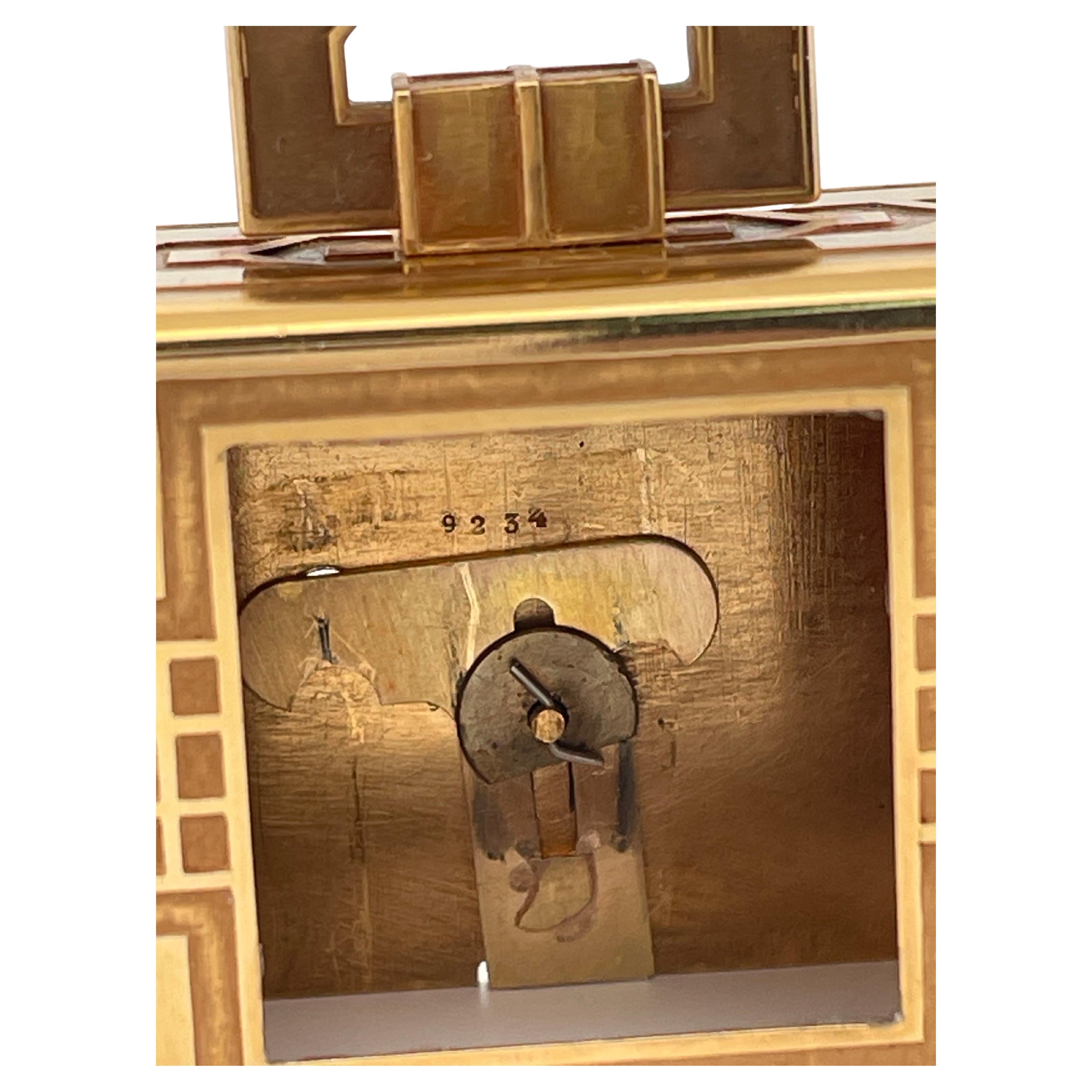 This rare Cartier 18K gold Art Deco travel clock embodies luxury, craftsmanship, and architectural elegance. Crafted in rich yellow gold, the clock features bold geometric motifs and a hinged handle reminiscent of a miniature handbag—an iconic nod