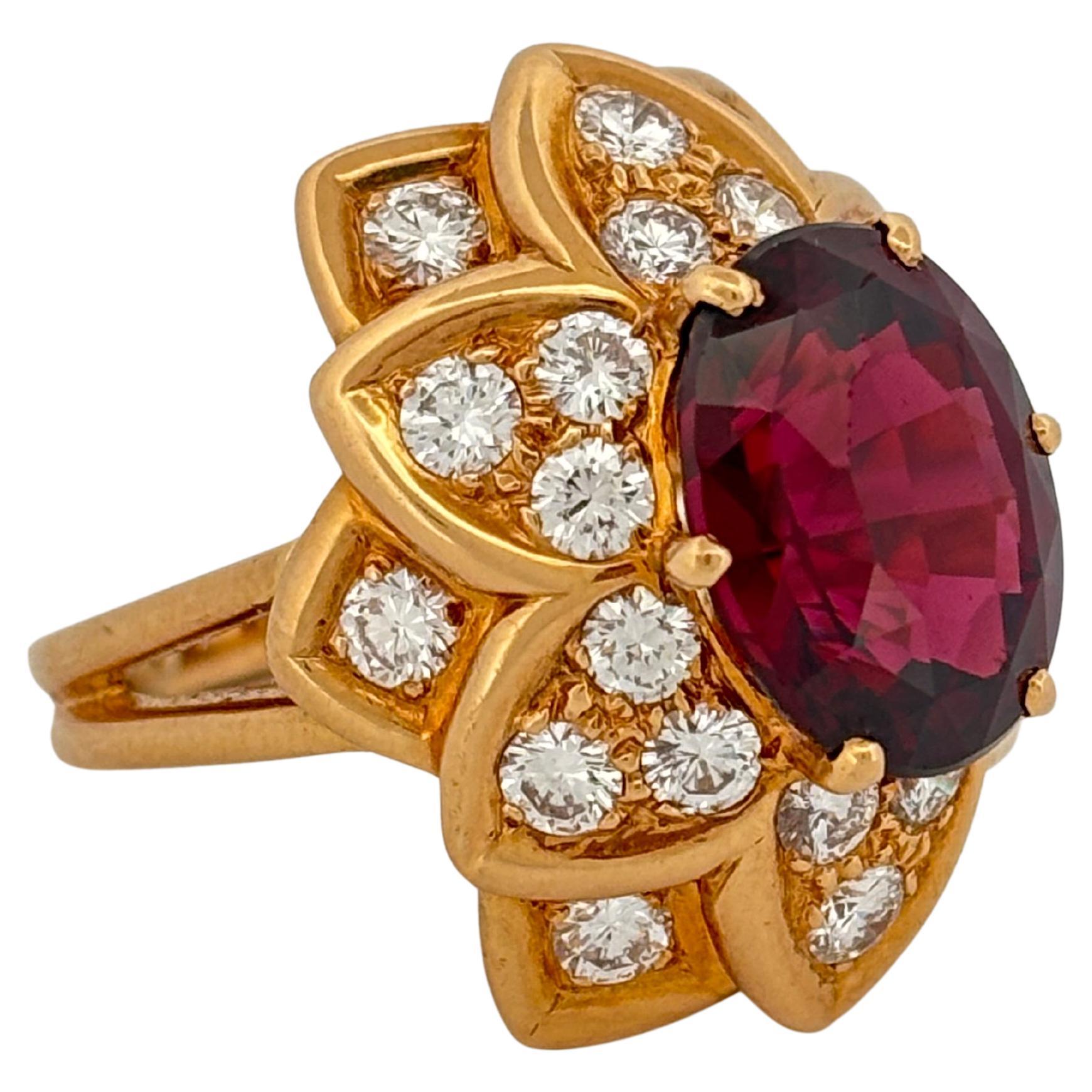 This striking 18K yellow gold ring weighing 16.6 grams showcases a vivid 7.00 carat-oval cut garnet at its center, radiating deep crimson hues with mesmerizing depth and brilliance. Surrounding the garnet is an intricate floral-inspired halo set
