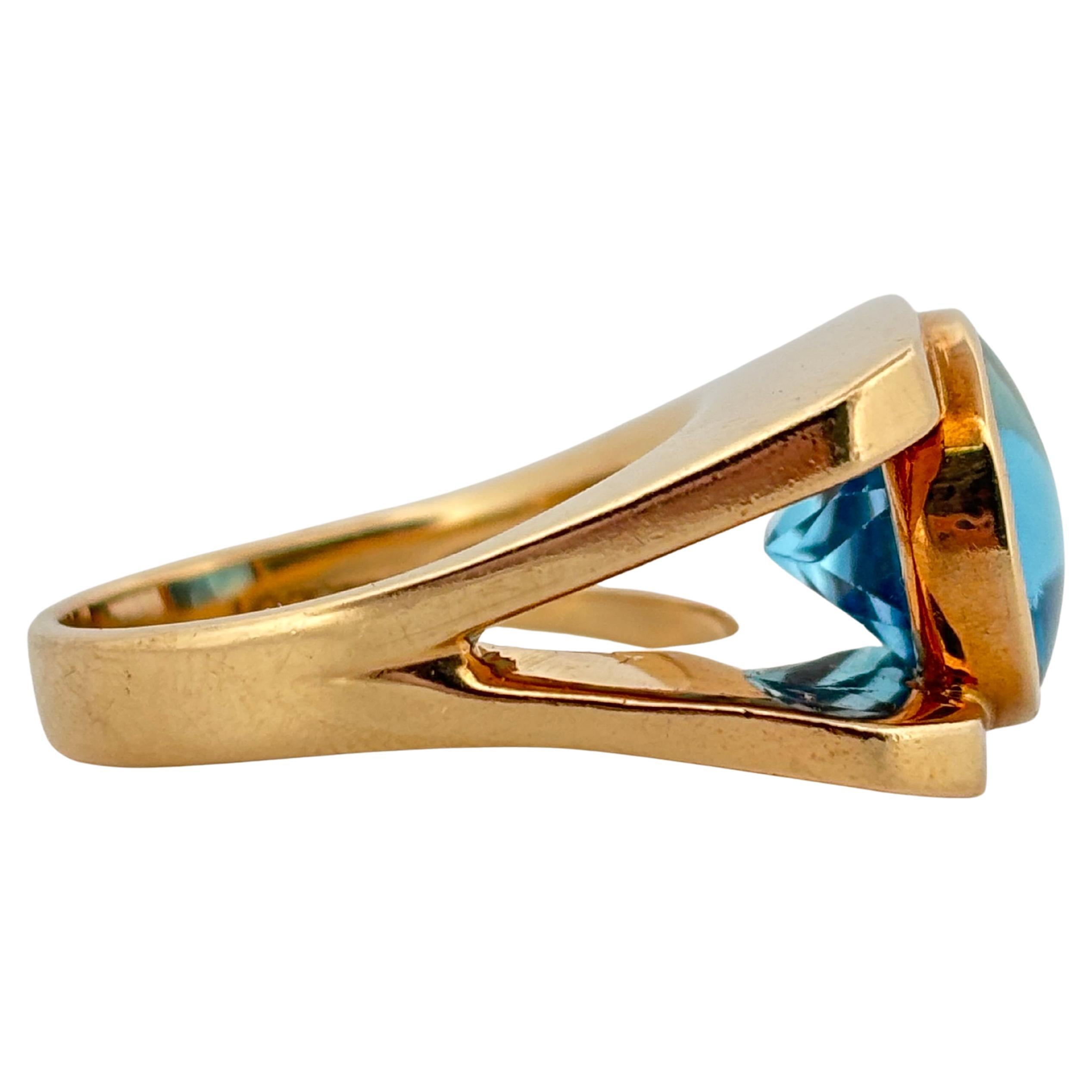 This striking 14k yellow gold ring showcases the captivating beauty of a Swiss blue topaz in an elegant, contemporary design. At its center rests an oval-cut topaz, celebrated for its vivid, crystalline blue hue that radiates brilliance with every