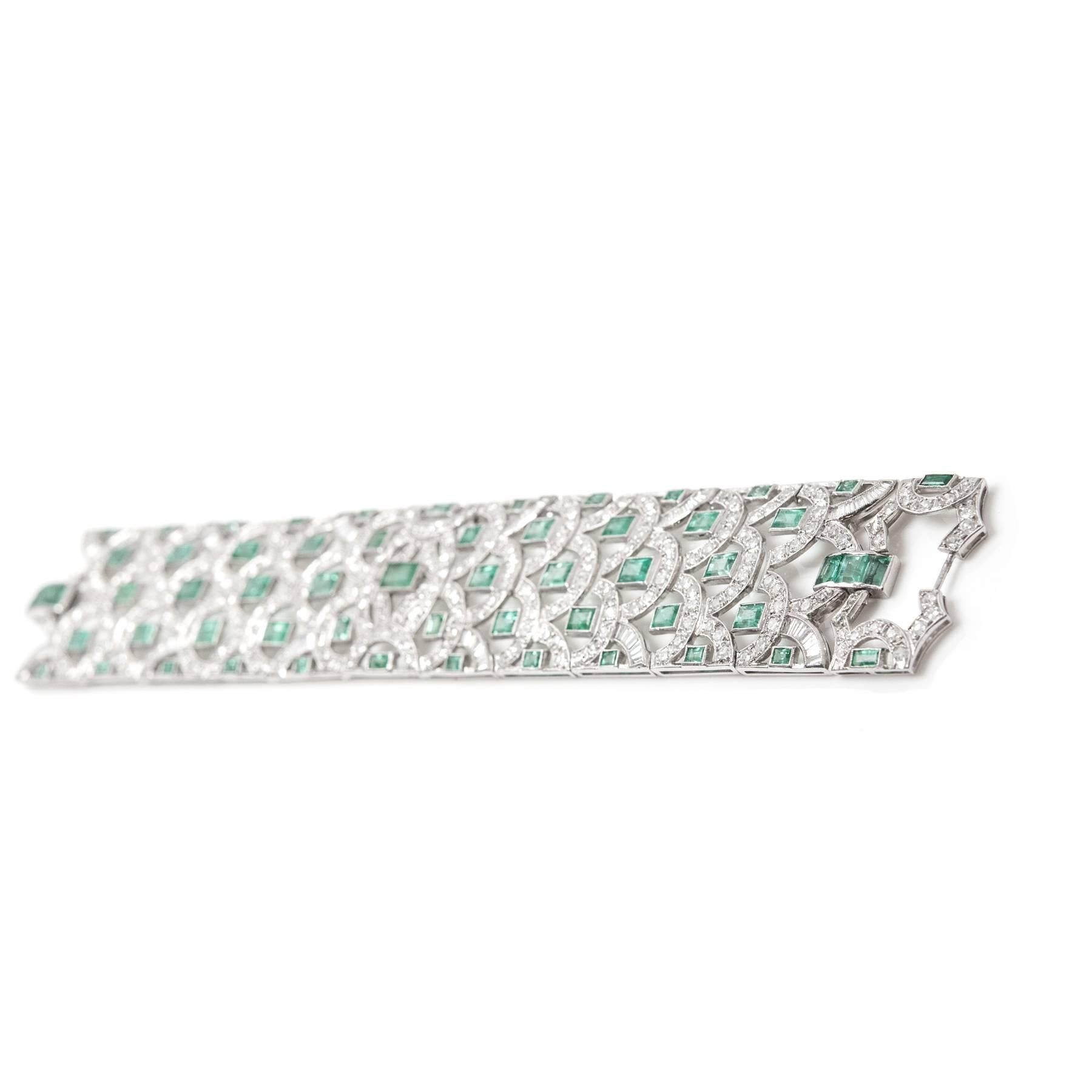 Ladies handmade Platinum scroll motif bracelet set with fifty-nine mixed cut Emeralds weighing 19 carats, additionally  et with tapered baguette cut, single cut, and old European cut diamonds weighing  approximately 11.5 carats.  Approximately 7.5”